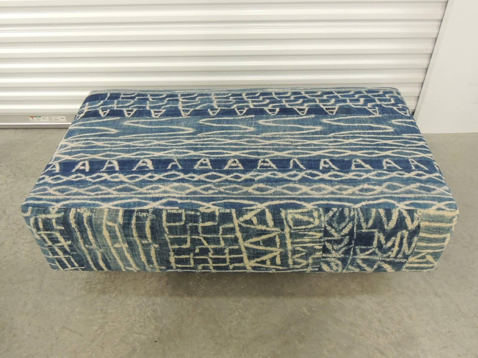 African blue and natural vintage Ndop textile upholstered ottoman textured finish.
African blue and natural vintage textile re-upholstered ottoman custom made and exclusively designed by us. Stripes of the African strip woven cotton were hand-sewn
