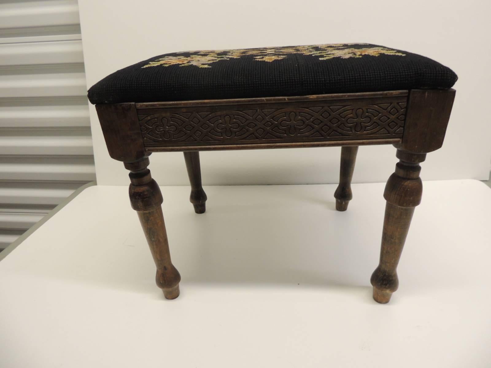 Vintage Gothic Style Footstool Reupholstered with Floral Tapestry Louis XVI Style Legs
Footstool with Louis XVI style fluted legs and reupholstered with a floral black antique tapestry with flowers; carvings all around the stretcher.  The flowers