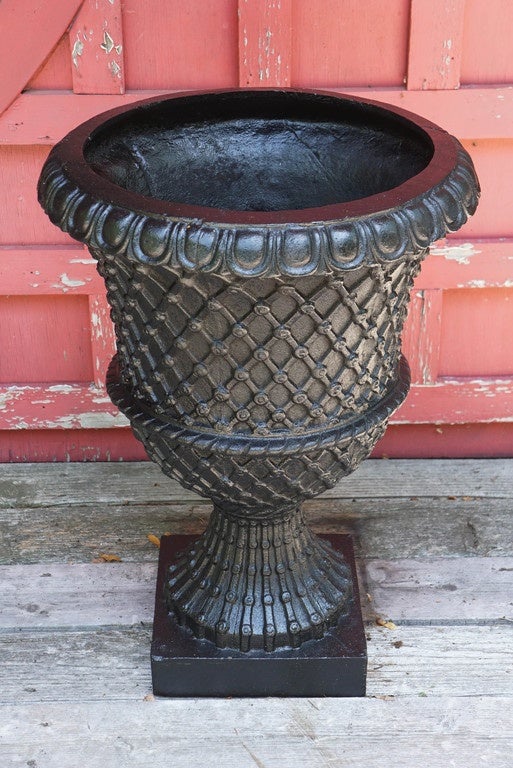 Handsome pair (two) of black painted Art Deco period cast iron garden urns. Basketweave pattern on the body of the urns with 