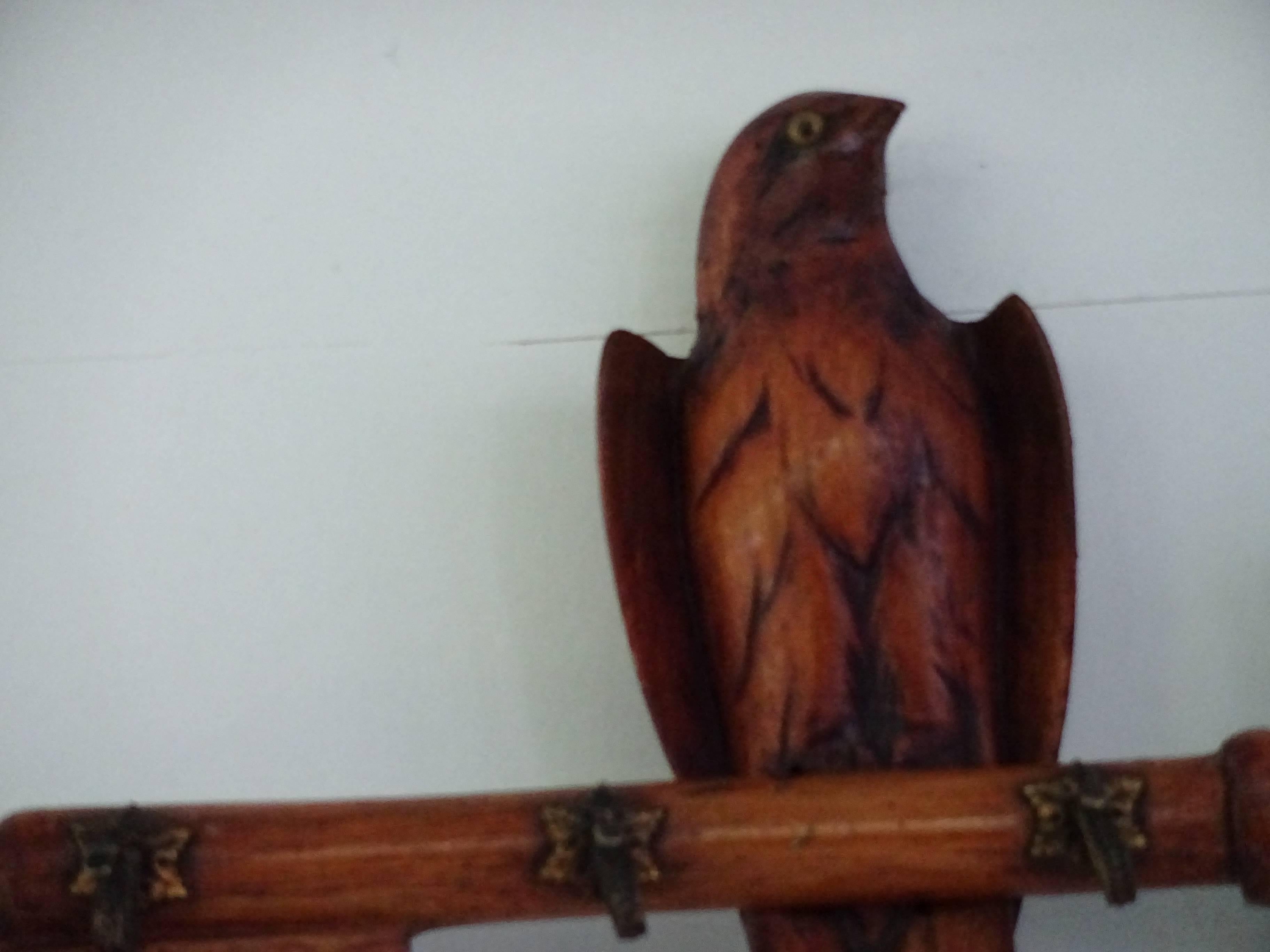 An Edwardian English carved coat hook in the form of a key with a bird
perched on to it. Four small metal hooks to hold clothing. Hanging hook
on the reverse side. Probably from a church with a cross carved into the
key.