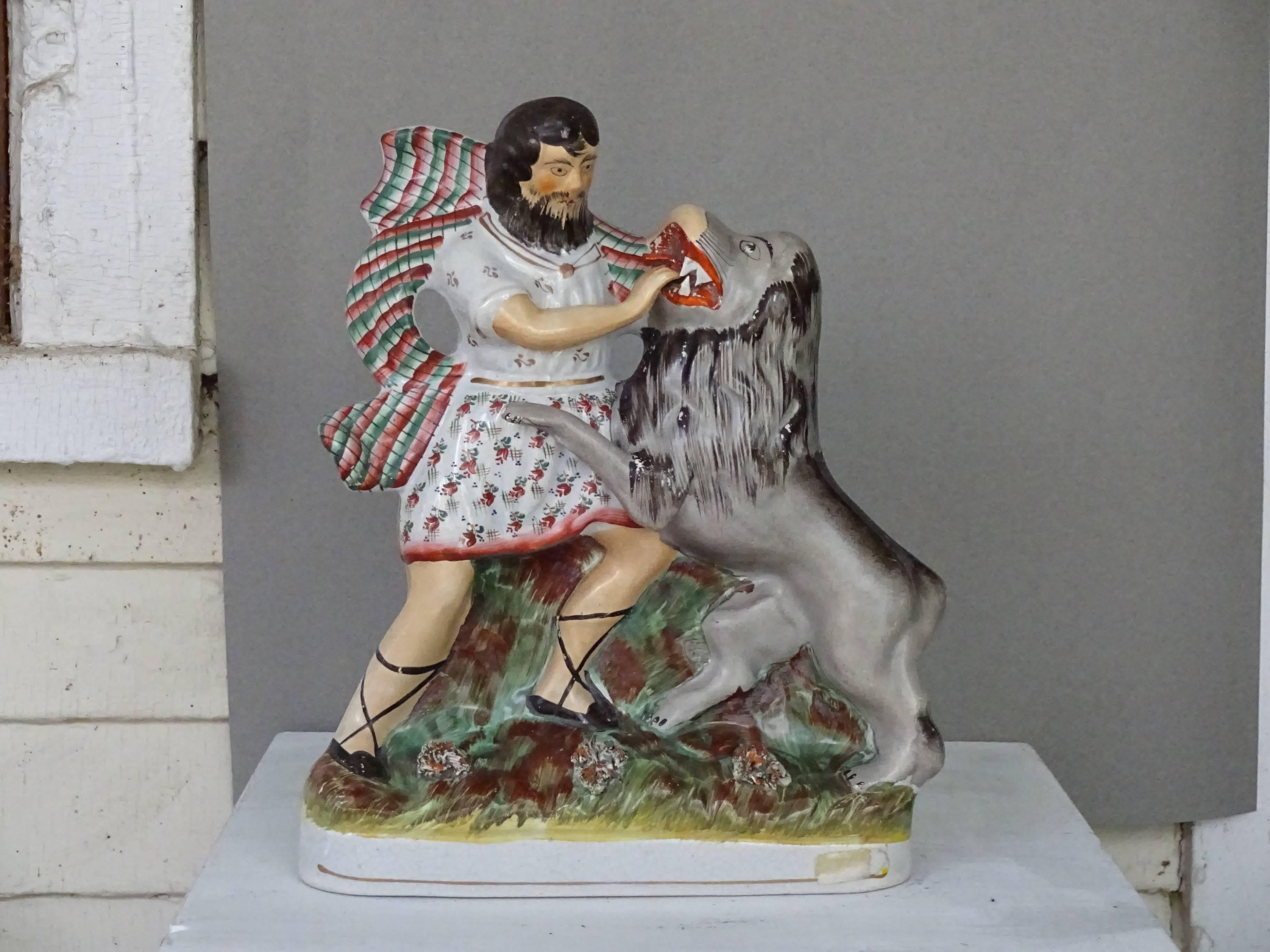 19th century Staffordshire figure of Hercules battling the Nemean lion. Hercules
attempting to strangle the beast, his hands in the beast's toothy mouth. Wonderful cloak thrown over his shoulder. On a porcelain marbleized base.