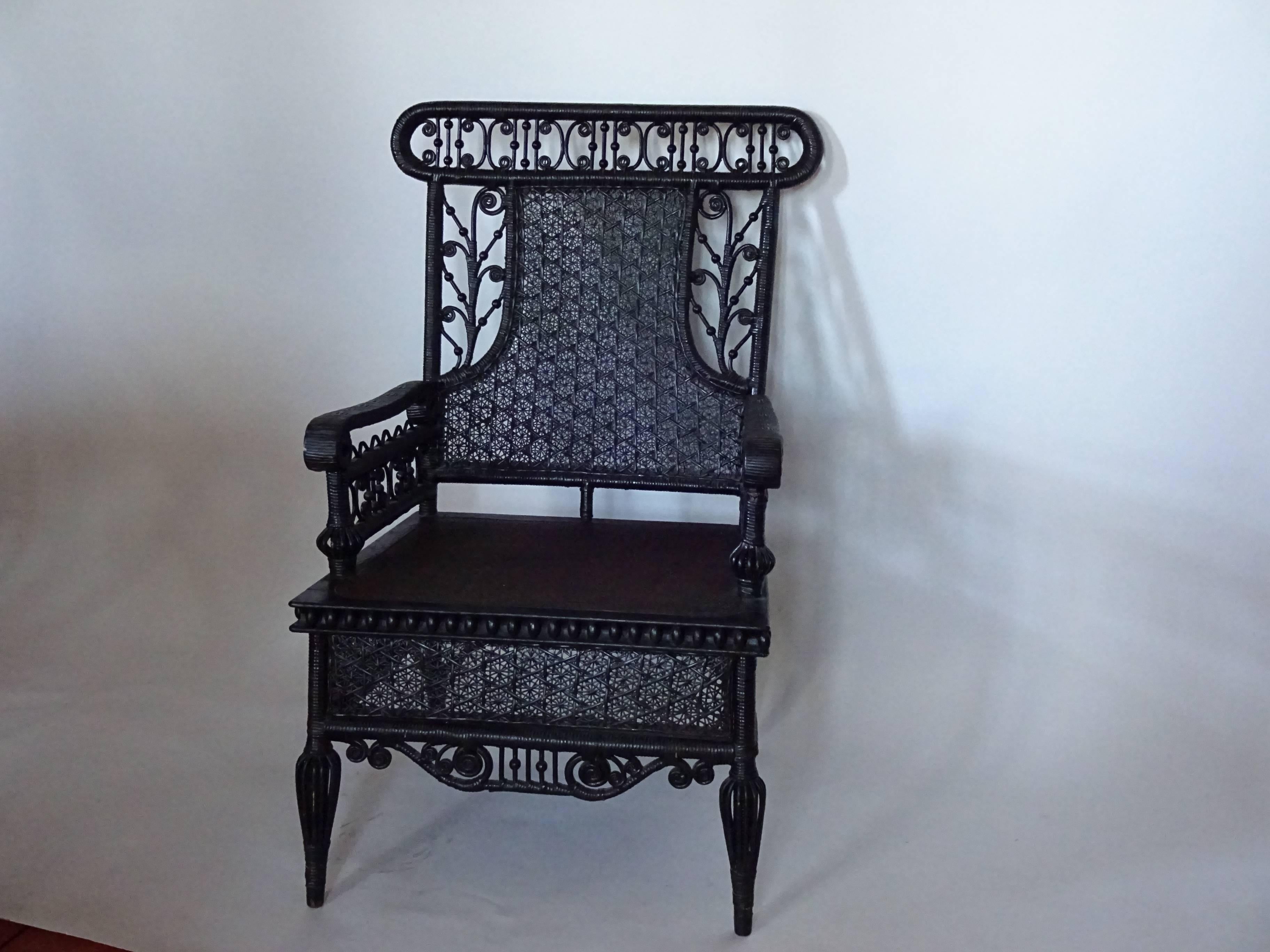 Victorian black painted wicker armchair. Heywood-Wakefield style. Fitted
with a chintz upholstered loose down cushion. Lovely, lacy wicker work. Height
to seat with cushion is 20.