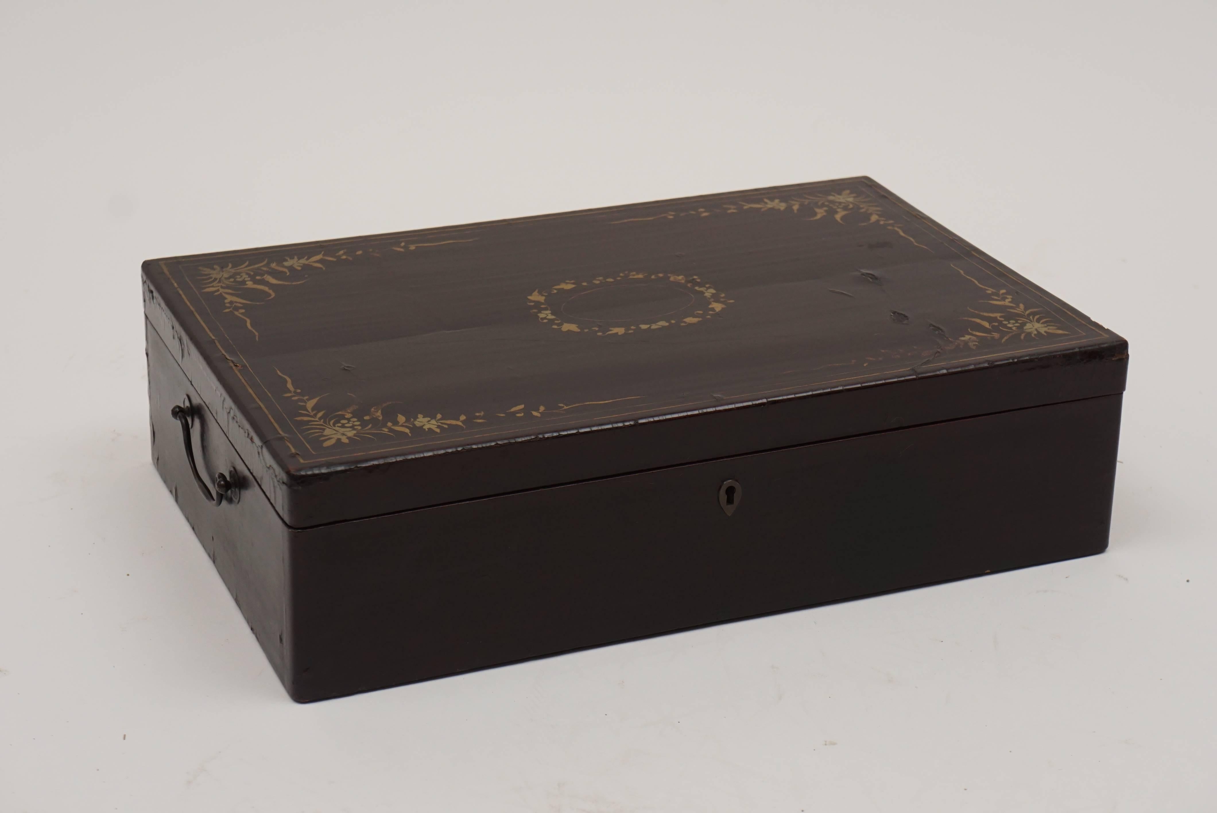 Late 18th-early 19th century Chinese export lacquer box. Made for European markets. Gold embellishments of swags and flowers decorate the lid of the box. Keyhole, but no key. Metal handles at either end of box to facilitate carrying. Small area on