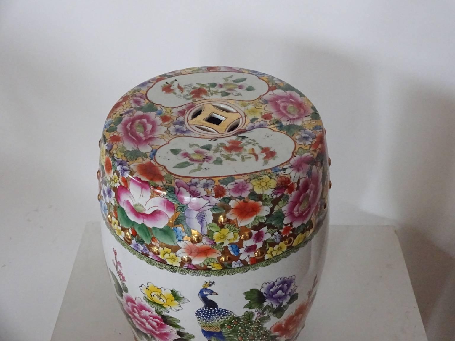 Peacock and peonies adorn this colorful Chinese barrel-form porcelain garden seat with lucky coin cutouts on the top and sides. Pinks, blues, yellows and greens stand out against the white ground. Hand-painted. Ideal for garden or porch or any