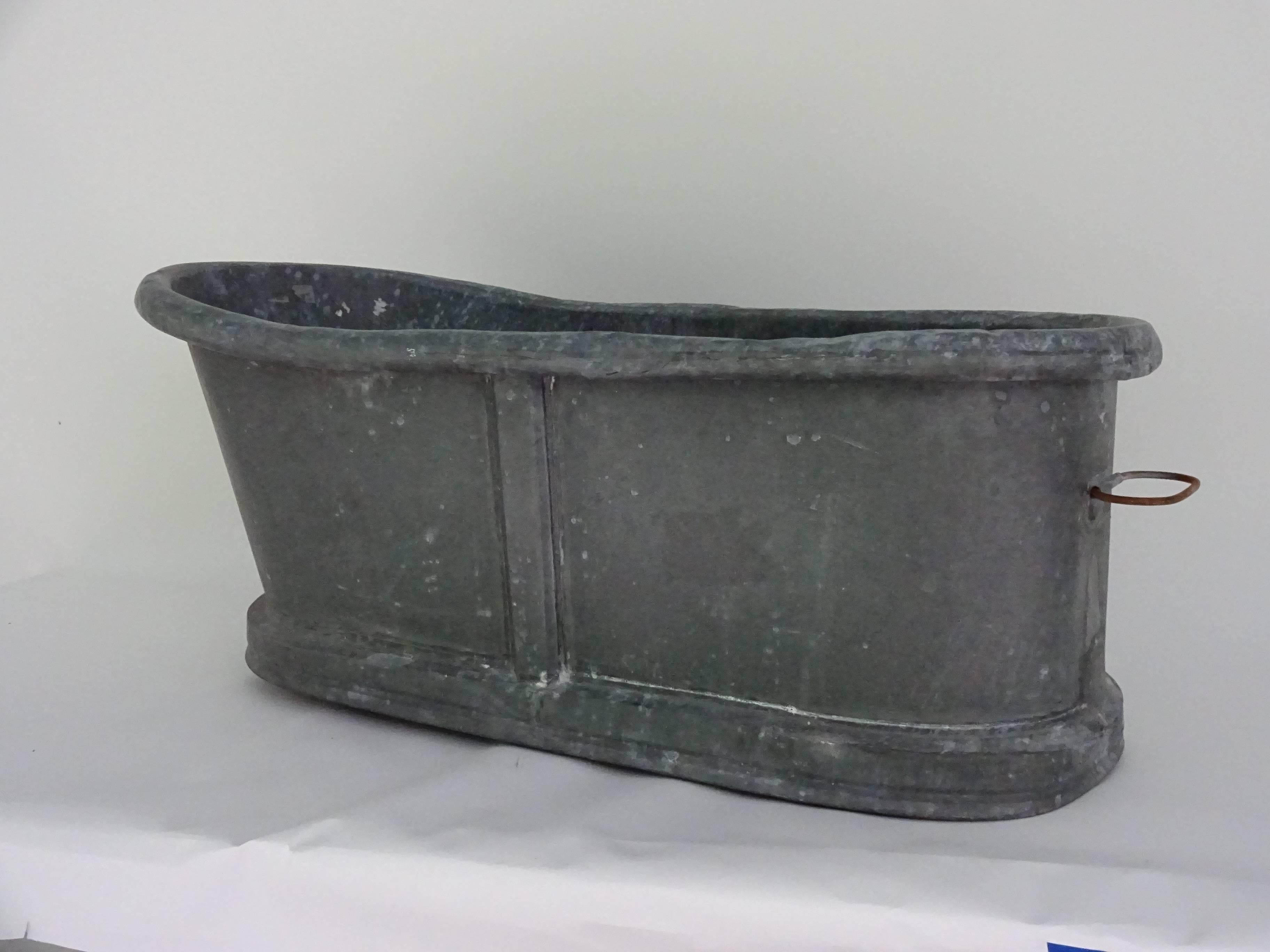 19th century zinc baby bathtub. English or American. Handles at either end. Good as a planter and also makes a wonderful ice bucket for a large party or reception. Fill it with ice and champagne. Zinc and wood.
