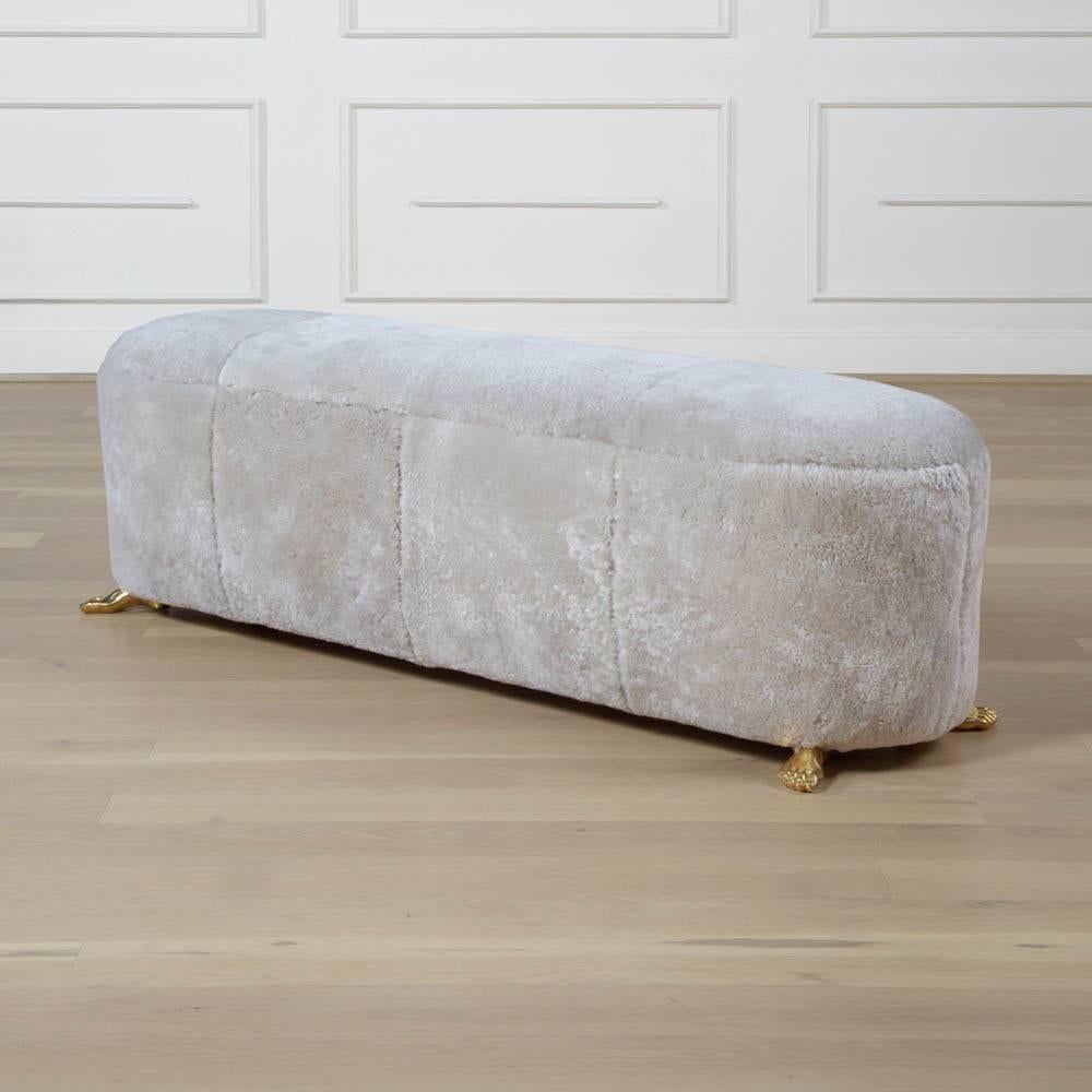 The foot bench is a natural partner to our popular foot stool. The soft curves of this bench are covered in luxurious natural shearling and mounted atop solid bronze cast feet. Unexpected and eye-catching, it is perfect as a bench at the foot of a