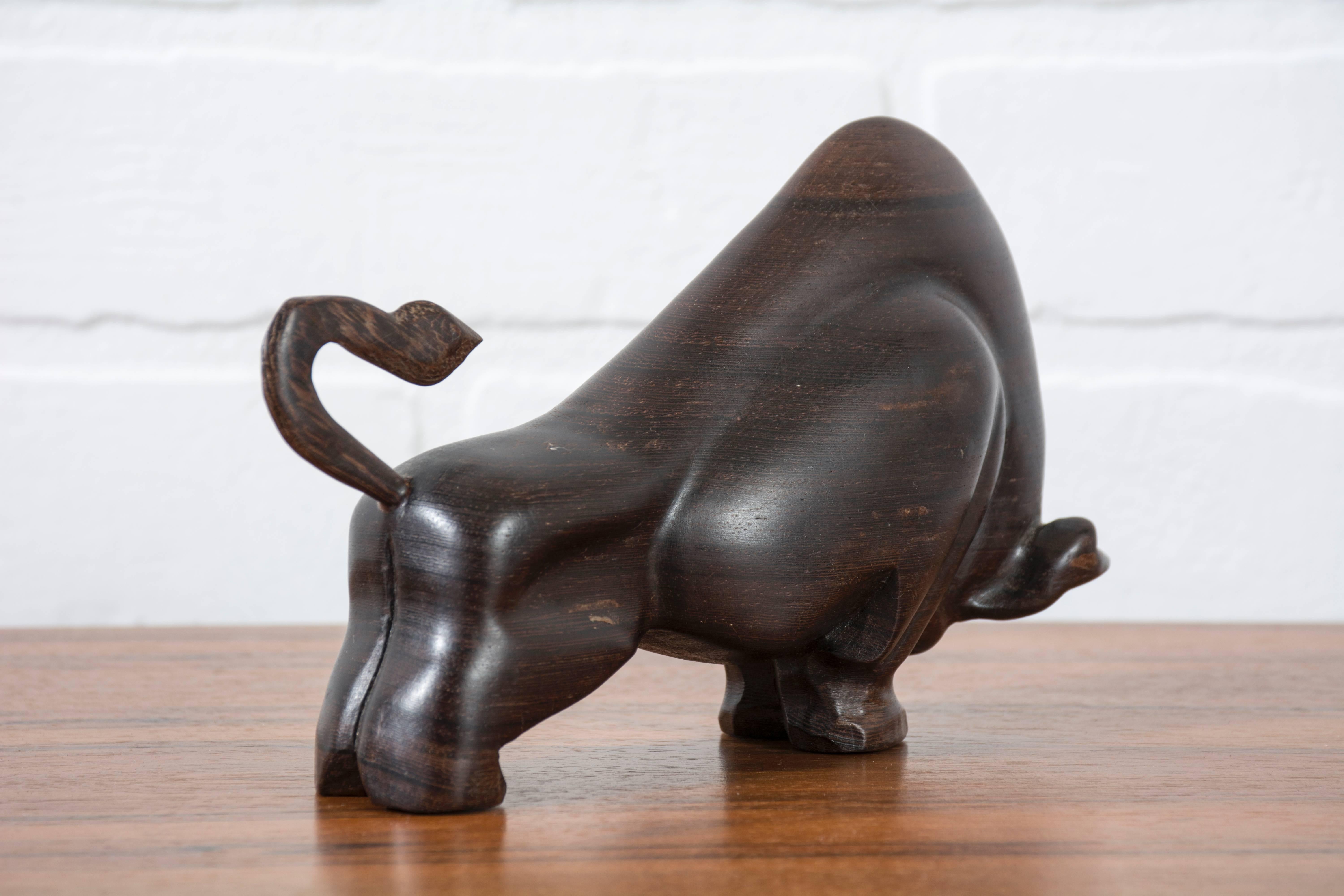 This is a vintage carved wood bull sculpture.