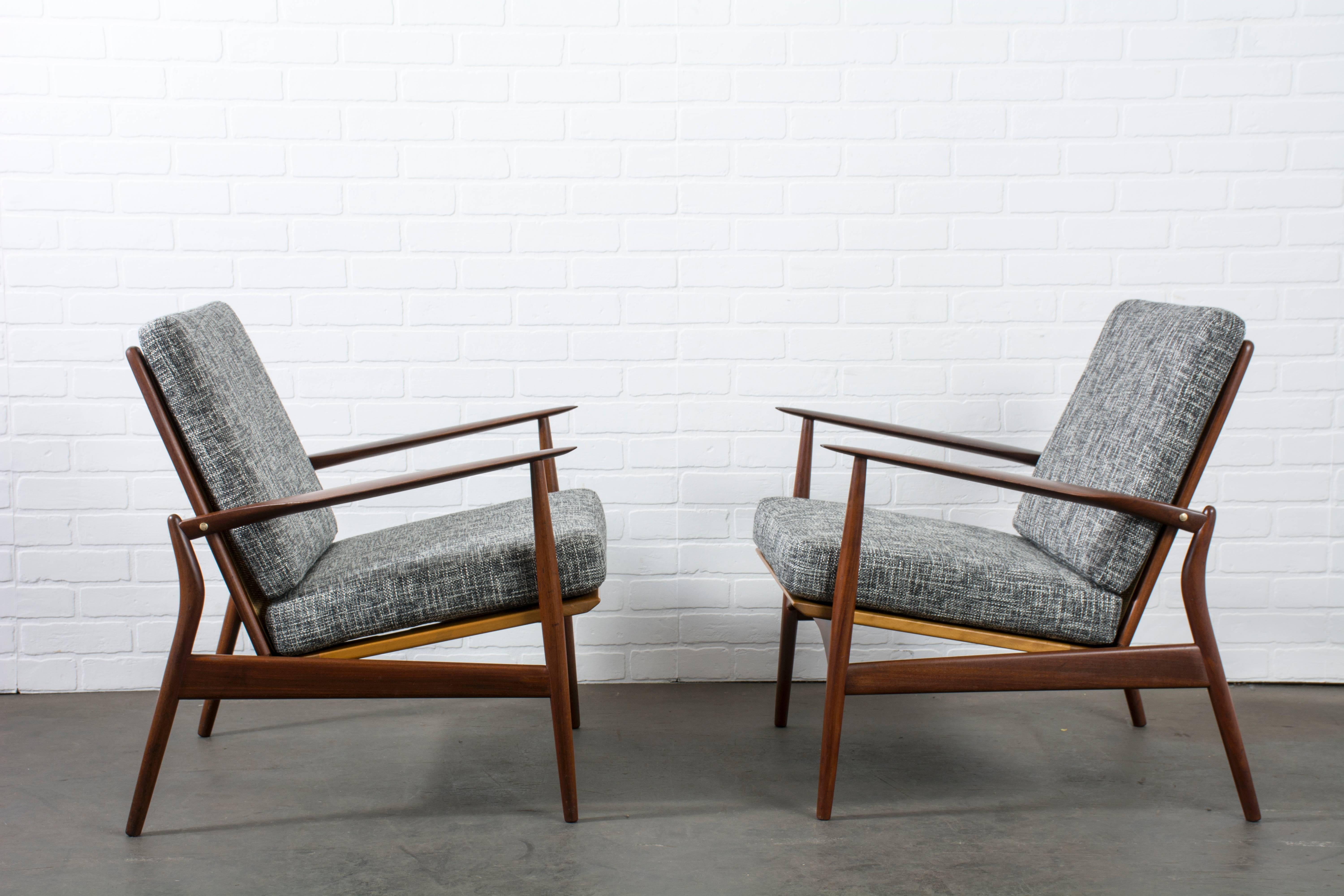 This is a pair of vintage Mid-Century 'spear' lounge chairs by Ib Kofod-Larsen for Selig (model #544 - 15), circa 1960's. They have walnut frames, cane backs, new upholstery, and new straps.