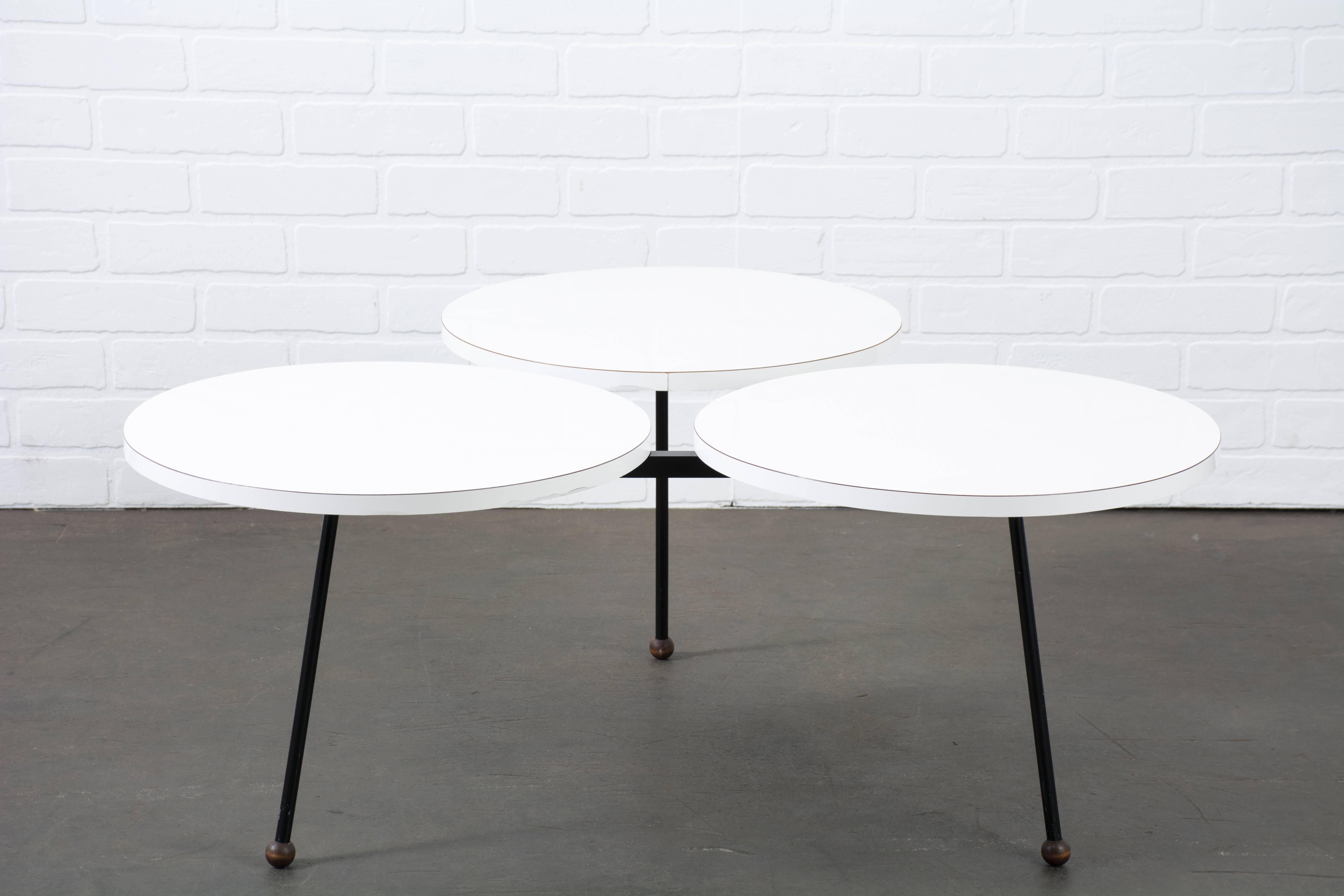 This vintage coffee table is in the manner of Greta Grossman, circa 1950s, Denmark. It features three circular white laminate tops on a black enameled steel base and wood ball feet.