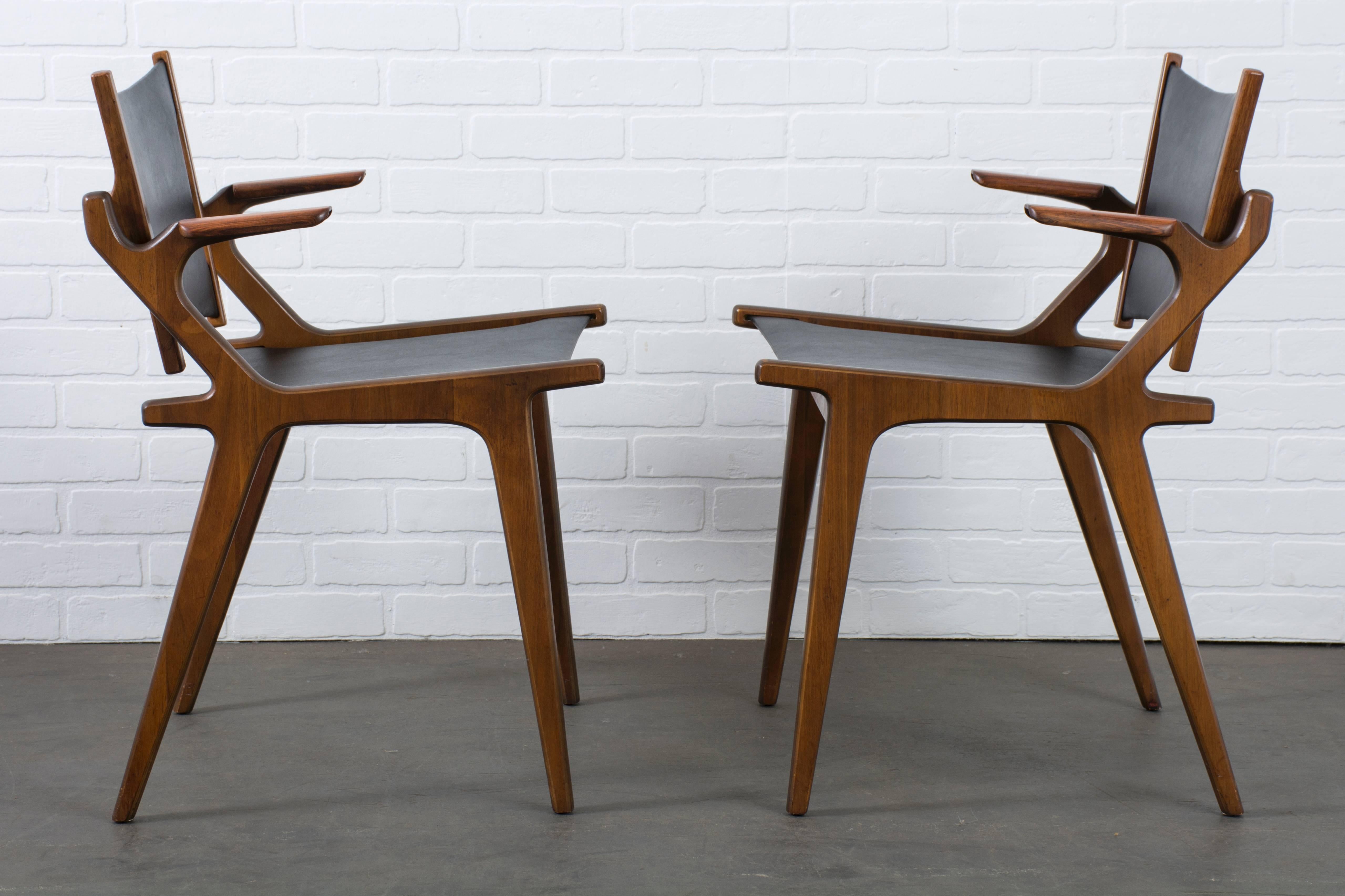This pair of rare Mid-Century Modern chairs was designed by Richard Thompson for Glenn of California, circa 1960s, USA. They have walnut frames with rosewood arms and the original black Naugahyde upholstery.