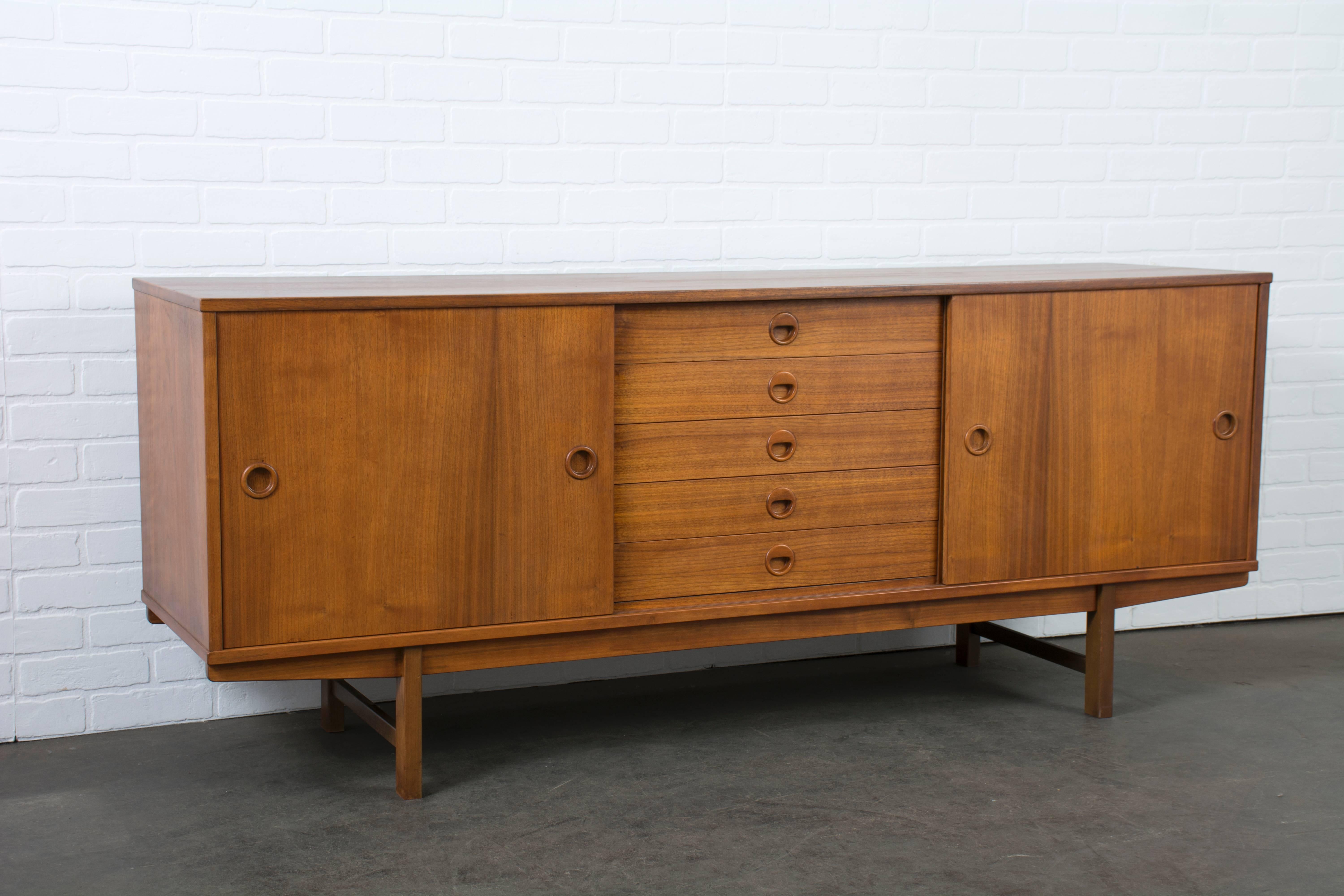 This vintage Mid-Century walnut credenza was designed by Yngve Ekstrom for DUX's Carmel Collection (Model 504) in the 1950s. It features two sliding doors and five drawers (one with dividers.)

    