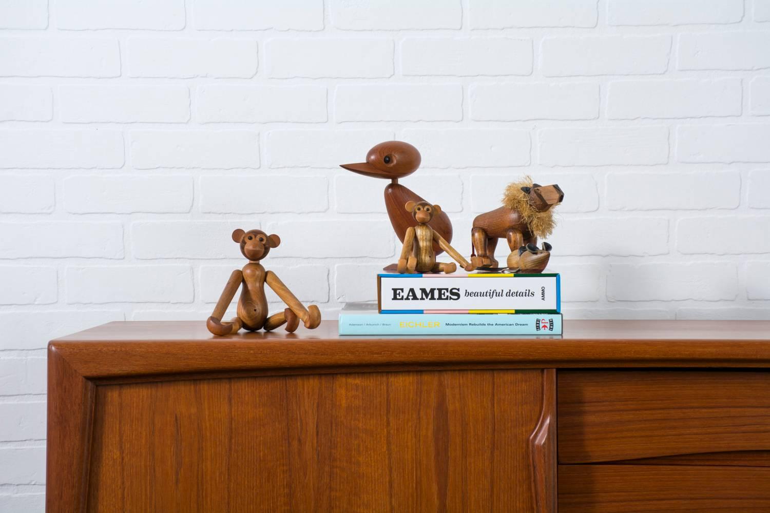 This is a set of six Mid-Century Modern articulating wood animal toys in the manner of Kay Bojensen, circa 1960s. They include a duck, two monkeys, a lion, and two mice. These animals are teak and oak with leather and rope details. The two monkeys