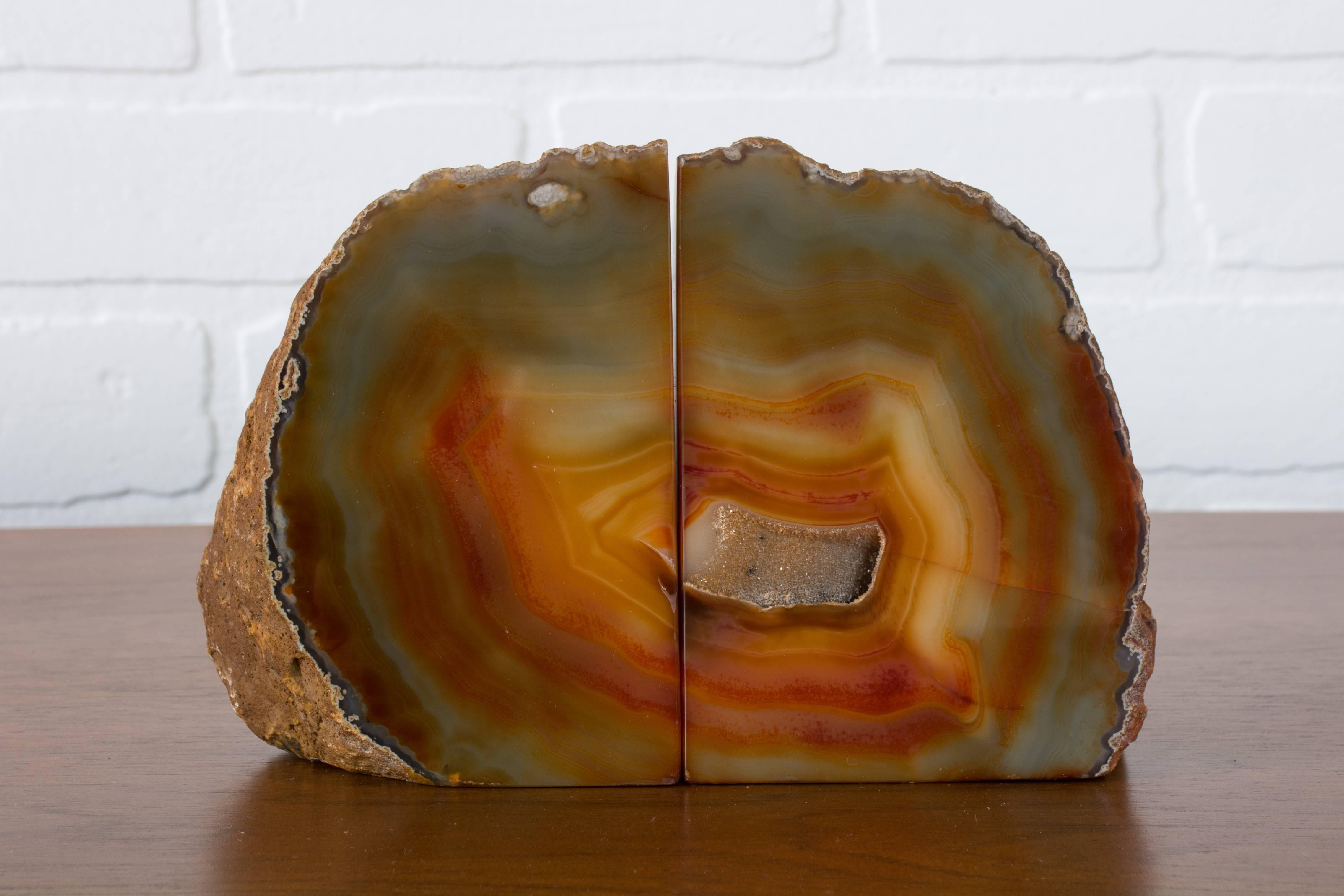 This is a pair of vintage geode bookends from Brazil. They have tones of orange, yellow, green, blue, grey and gold.
