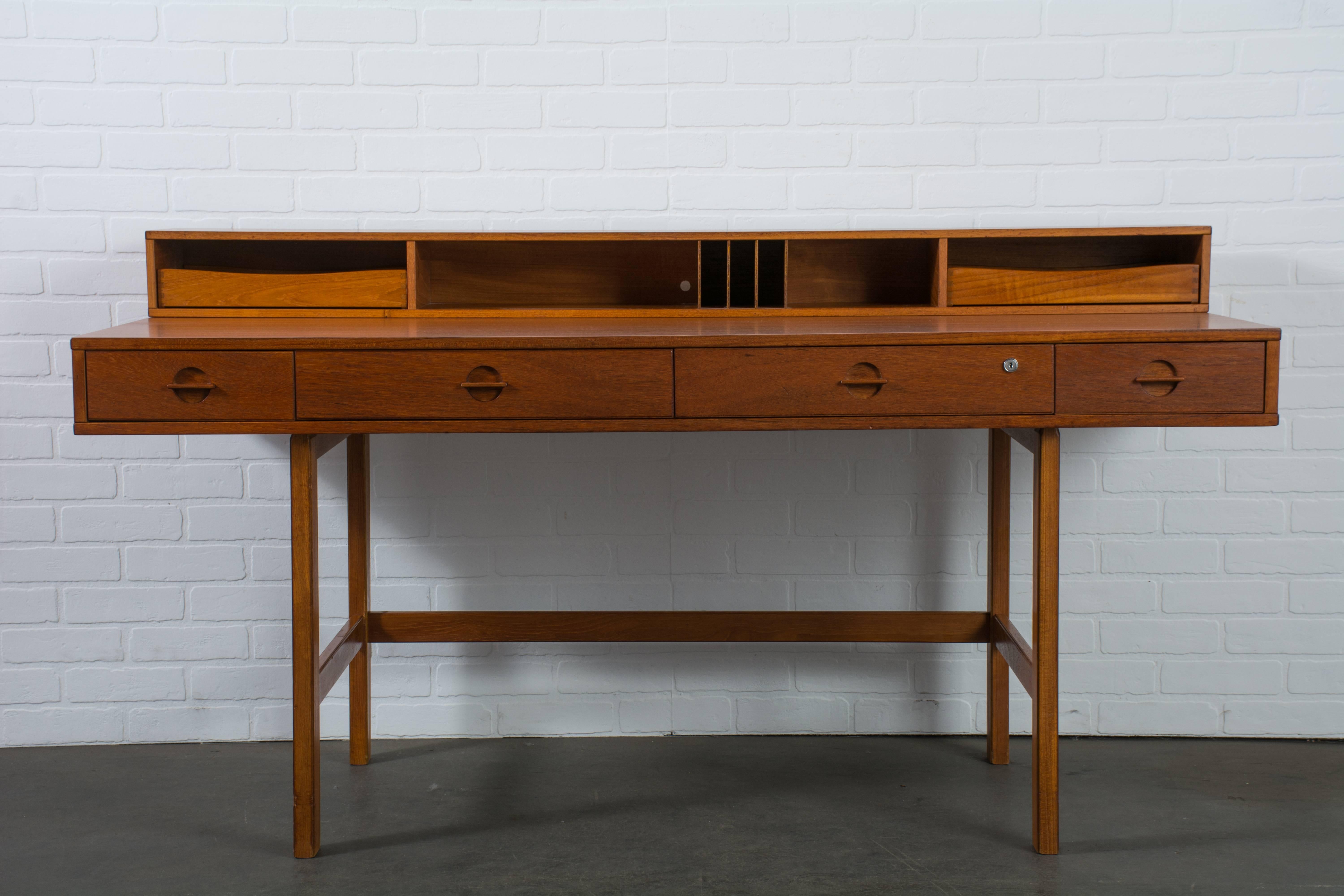 This vintage Mid-Century flip top teak desk was designed by Peter Lovig Nielsen for Lovig in the 1960s, Denmark. The top which includes shelves and small drawers or letter trays can be folded down to extend the space of the desk top or to use it as