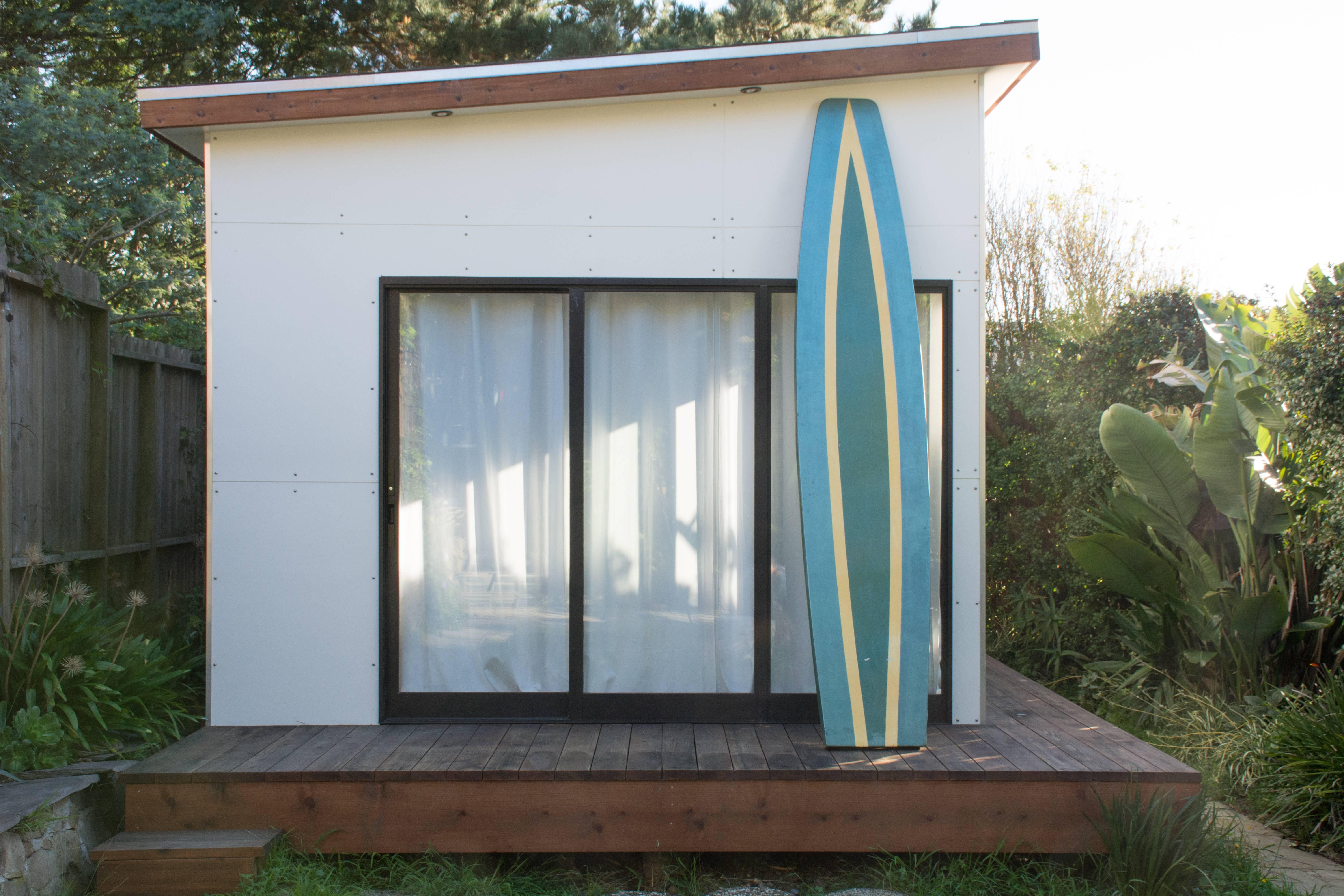 This vintage midcentury hollow surf or paddle board is in the style of Tom Blake.  It is constructed of balsa wood and is painted in green, yellow, and blue.  It can still be used, but is great as a unique collector's item.