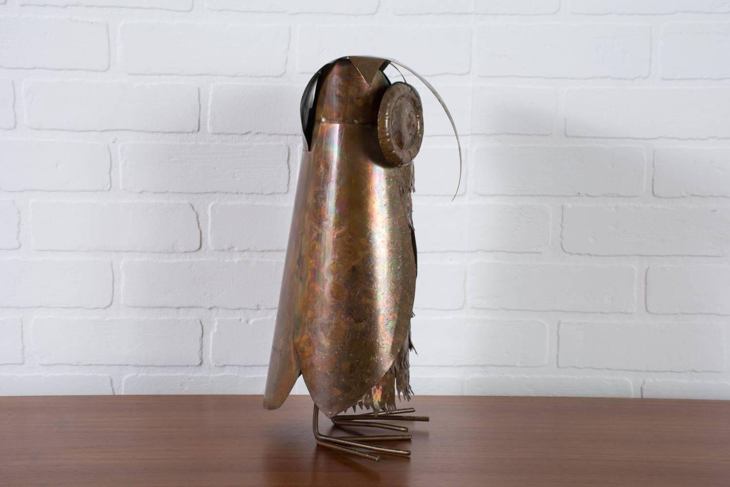 This Mid-Century Modern owl sculpture is metal with a copper finish.

 