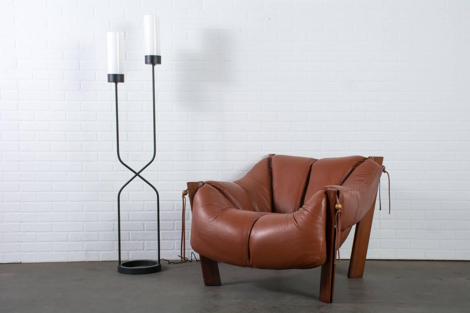 This Mid-Century Modern floor lamp was designed by San Francisco Bay Area designer, Robert Bulmore (1924-2016) in the 1950s. The cast iron ring base supports two rods that cross each other and hold two milk glass diffusers at different heights