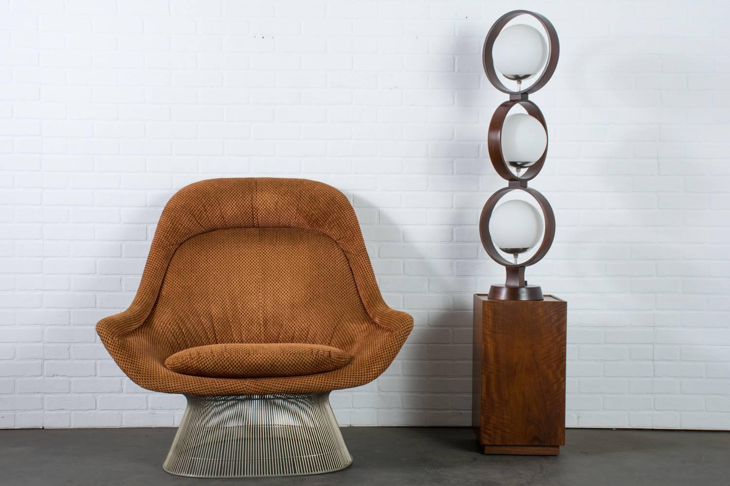 This Mid-Century Modern large table lamp is by Modeline. Its sculptural form consists of three walnut rings staggered on top of each other, each one containing one frosted glass globe. Chrome details. Switch is on the base.