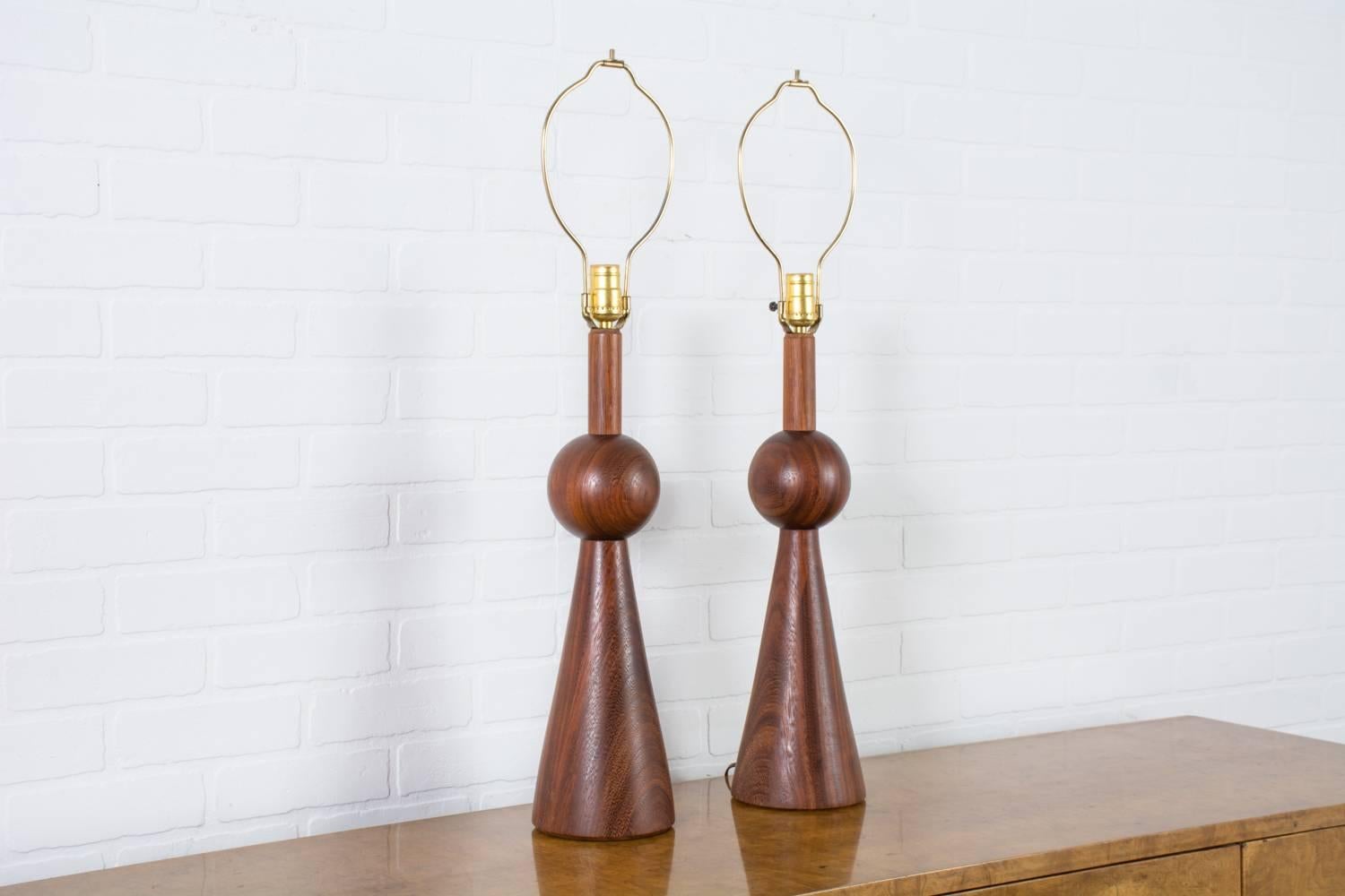 This is a pair of Mid-Century Modern geometric walnut table lamps. They measure 20.5 inches H to the top of the sculptural wood bases and currently have 10 inch high harps.