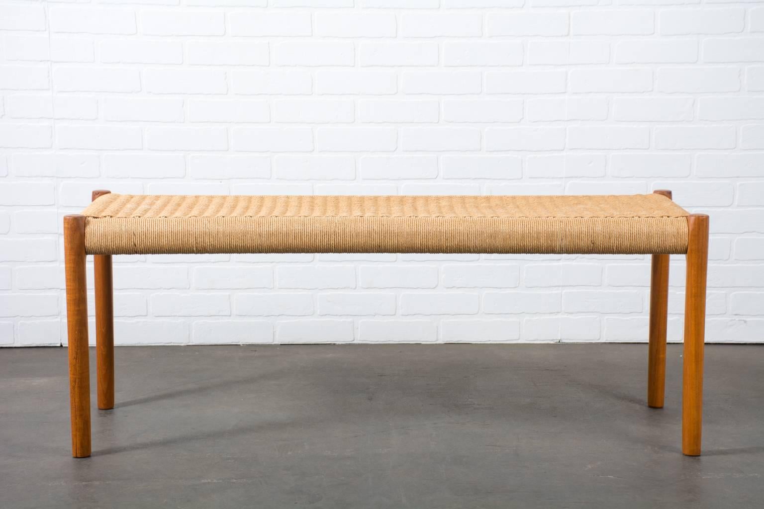 This vintage Mid-Century bench, model 63B, was designed by Niels O. Møller for J.L. Møllers Møbelfabrik, Denmark, 1960s. It has teak legs and a woven rope seat.