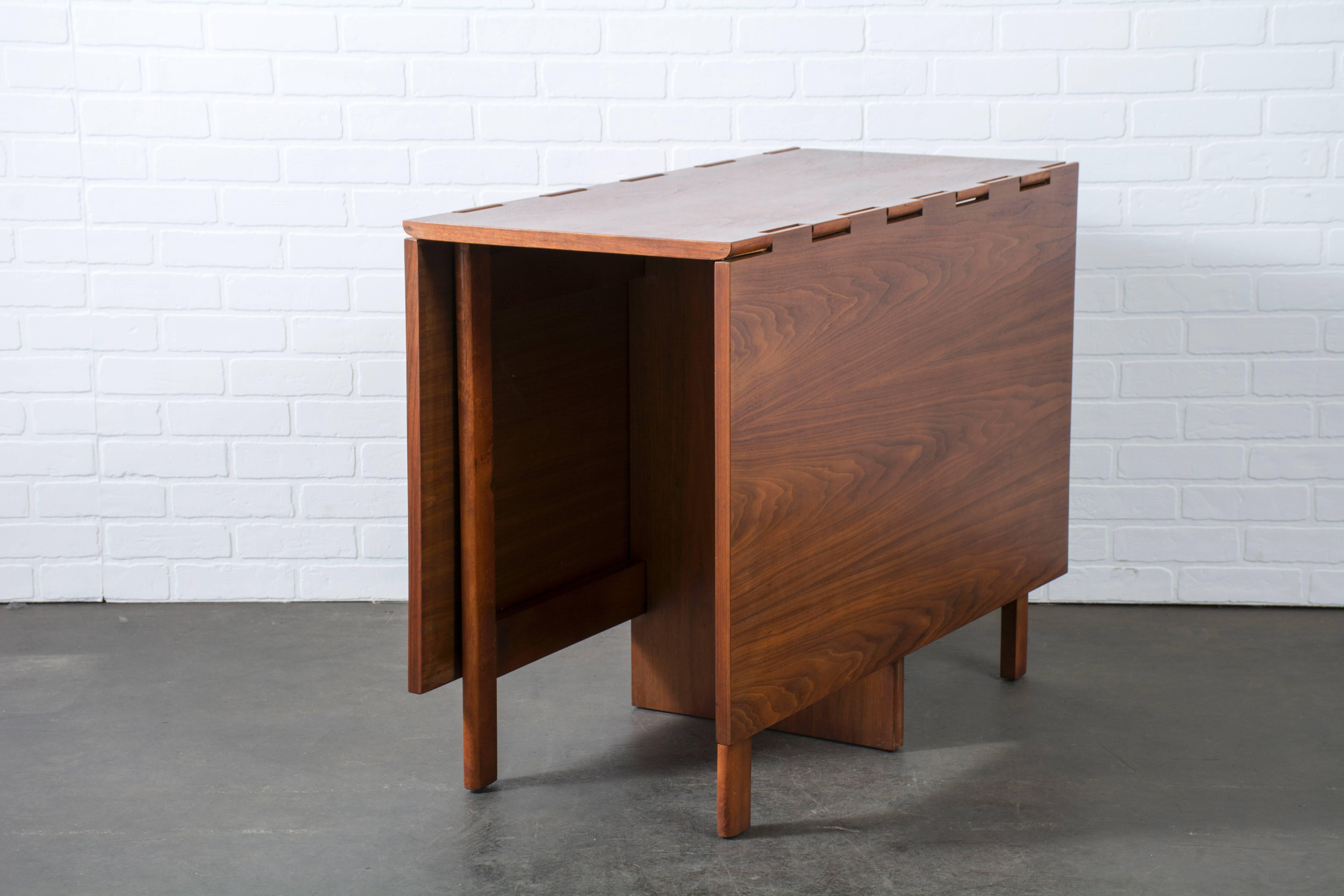 This walnut drop-leaf dining table was designed by George Nelson for Herman Miller in the 1950s. It can be used as a desk, work table or dining table that seats up to six. Measures: 18.5
