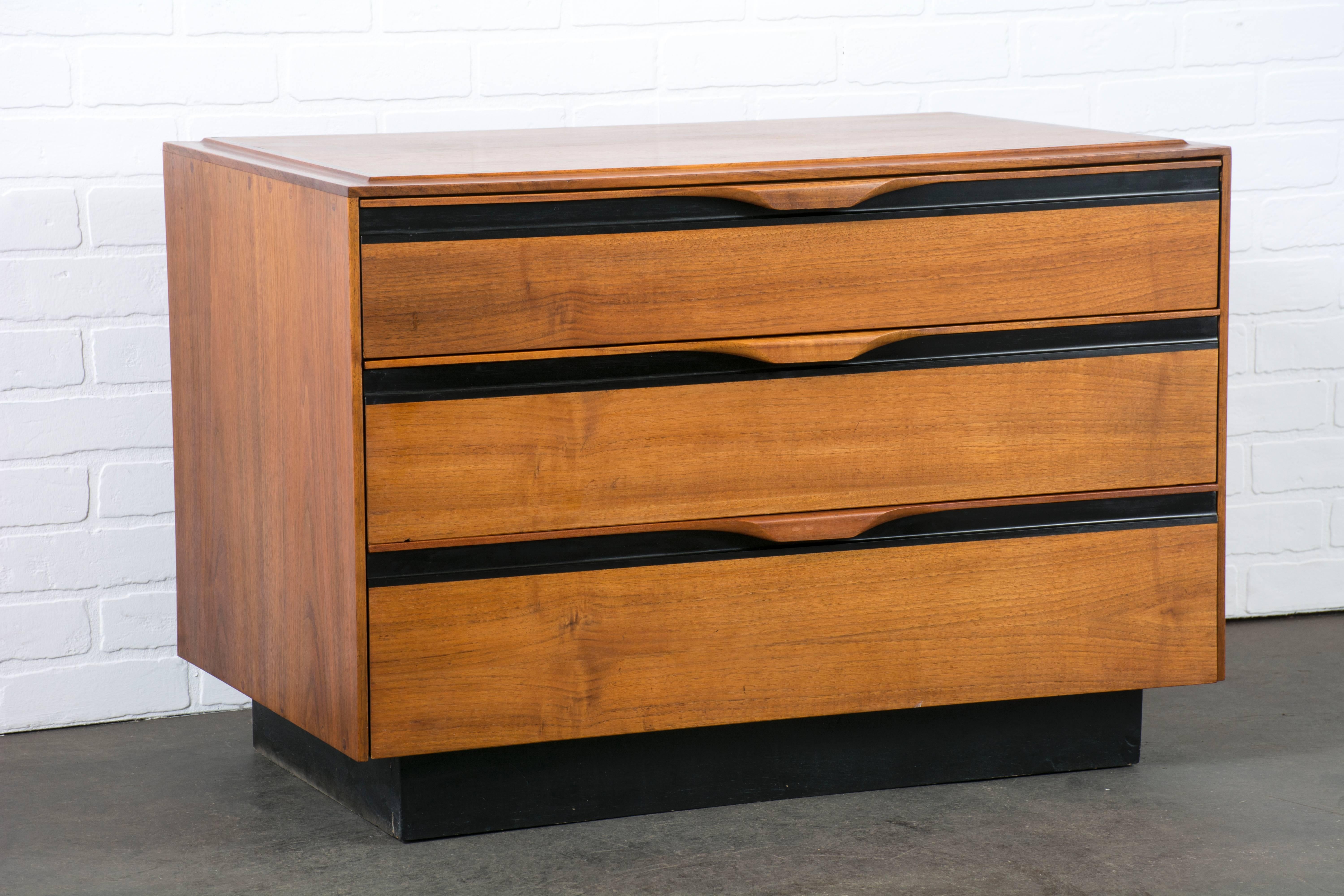 This Mid-Century Modern three-drawer dresser was designed by John Kapel for Glenn of California in the 1960s. It is walnut with black details. Matching gentleman's chest/armoire available separately.