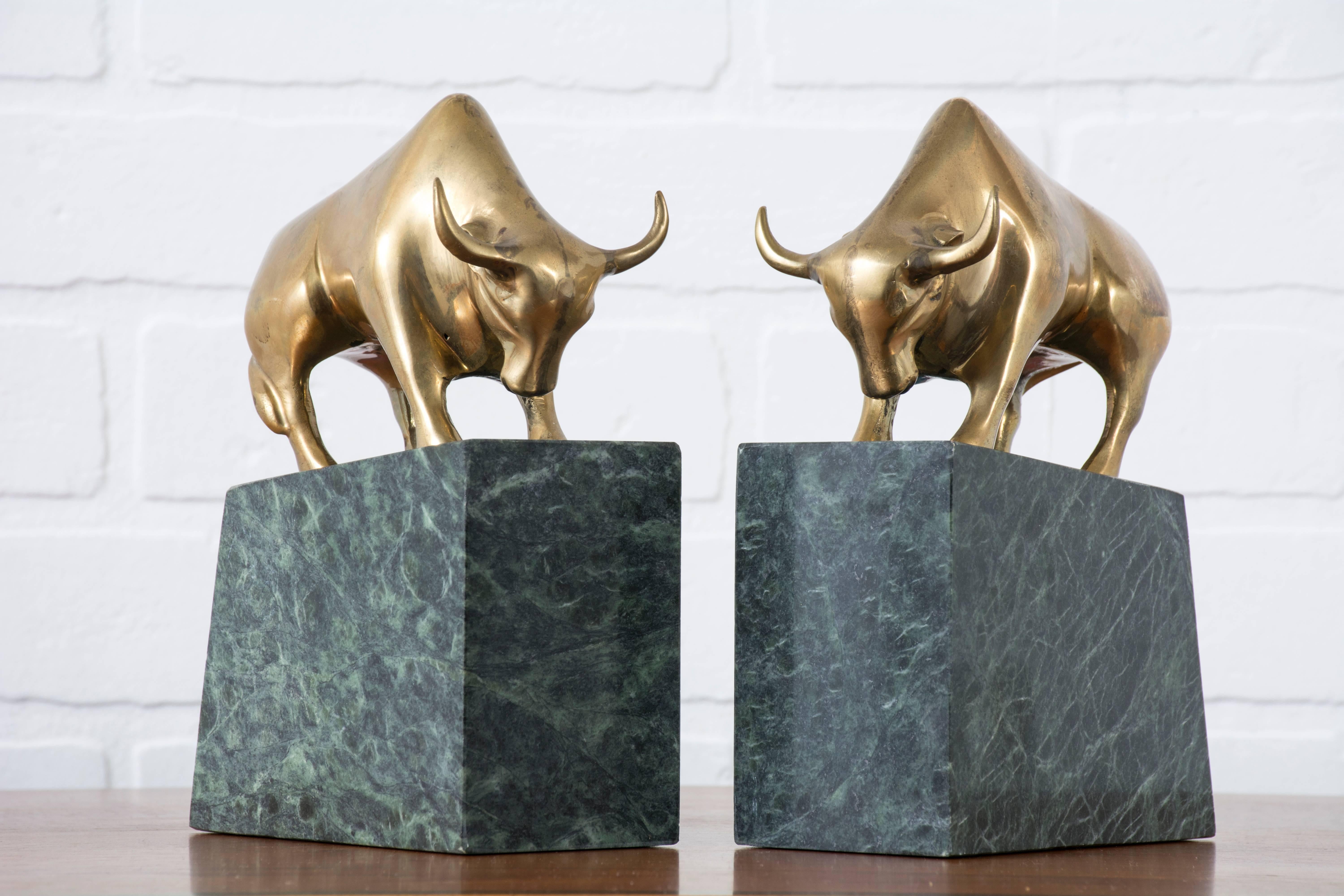 This is a pair of vintage bookends with brass bulls and green marble pedestals.
