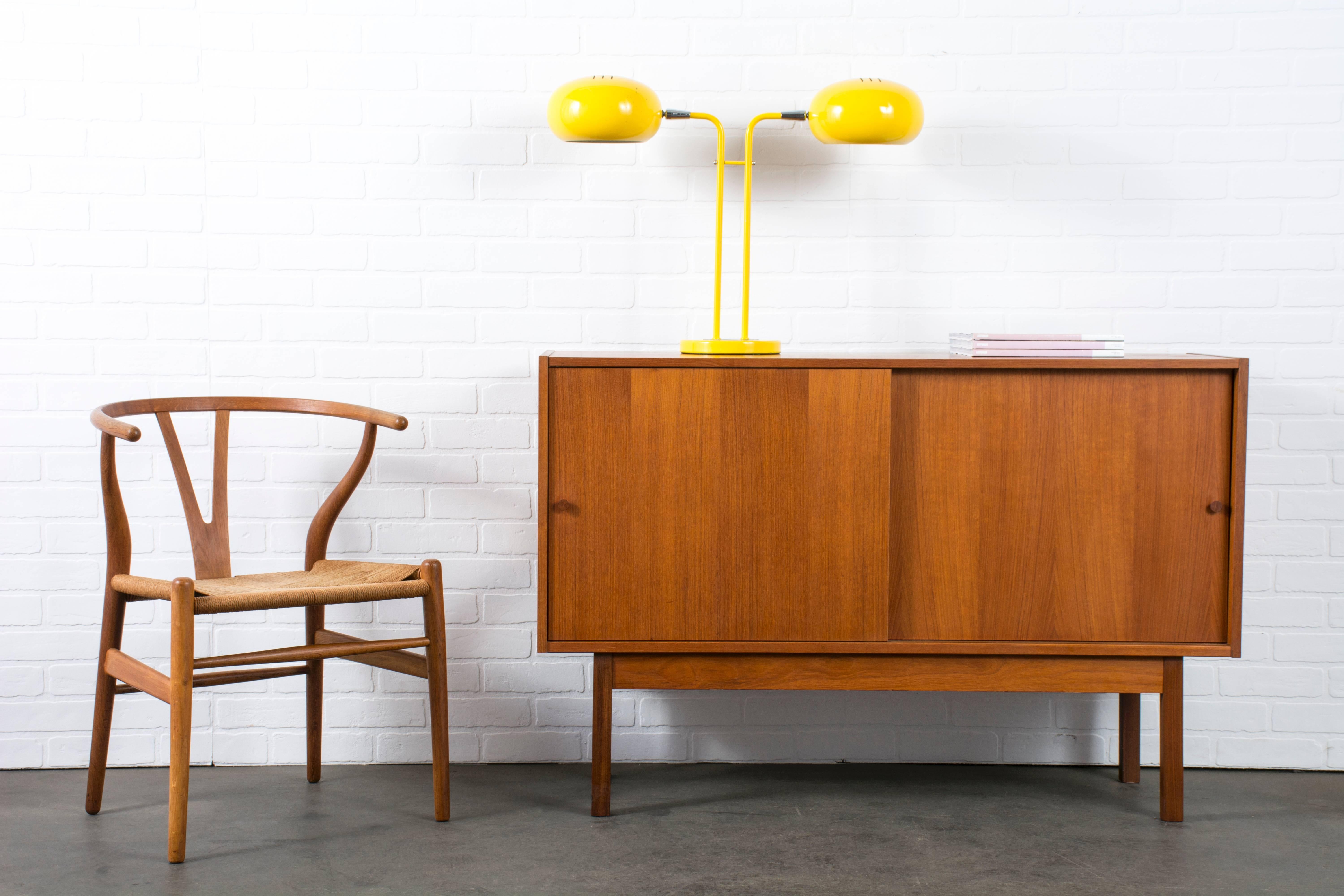This is a vintage Mid-Century yellow desk lamp with two shades. The shades tilt and can be turned on separately (switch below each shade). Chrome details.
