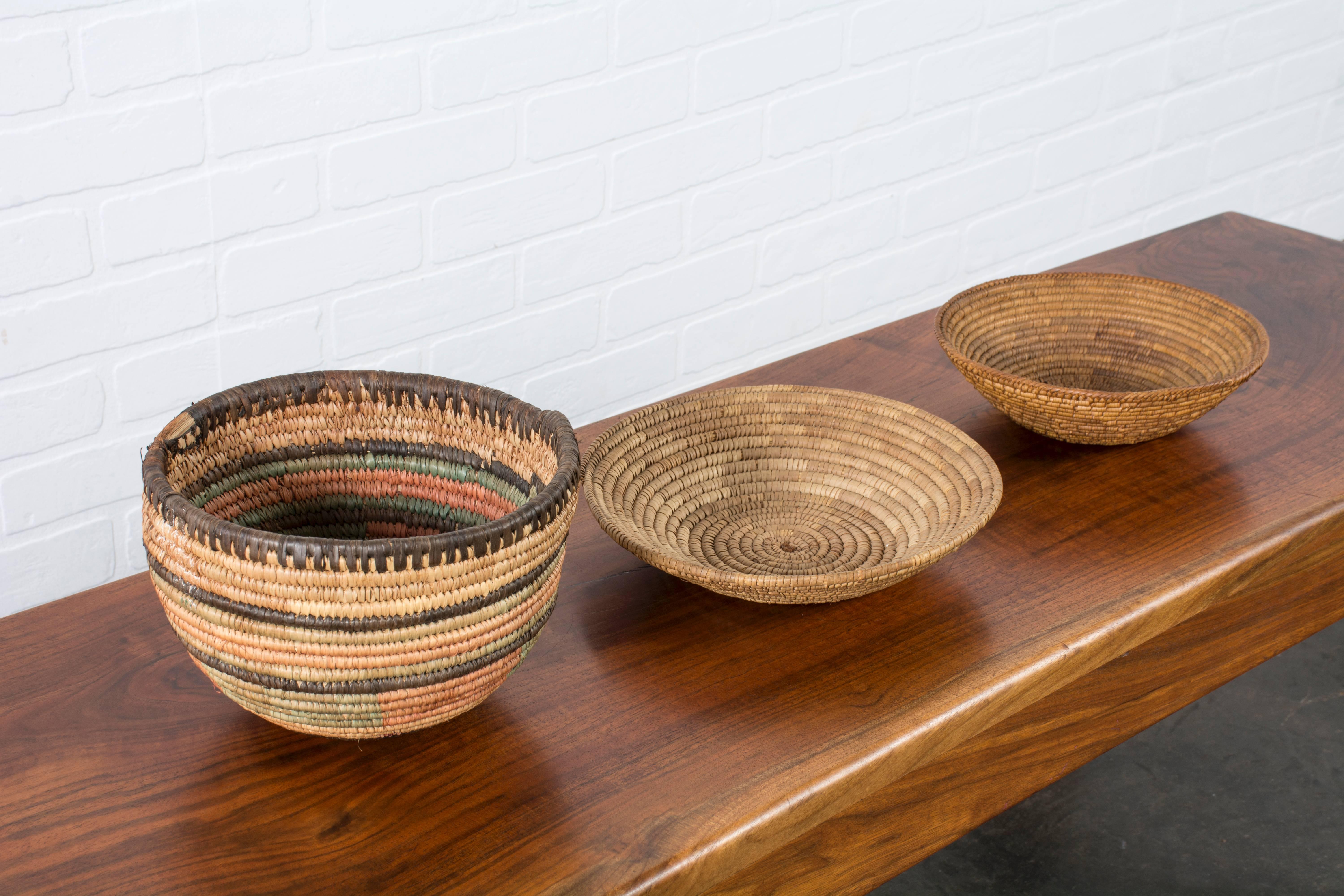 This is a set of three Native American baskets. Measurements: Left: 9"diameter, middle: 10.13"diameter, right: 8.63"diameter.