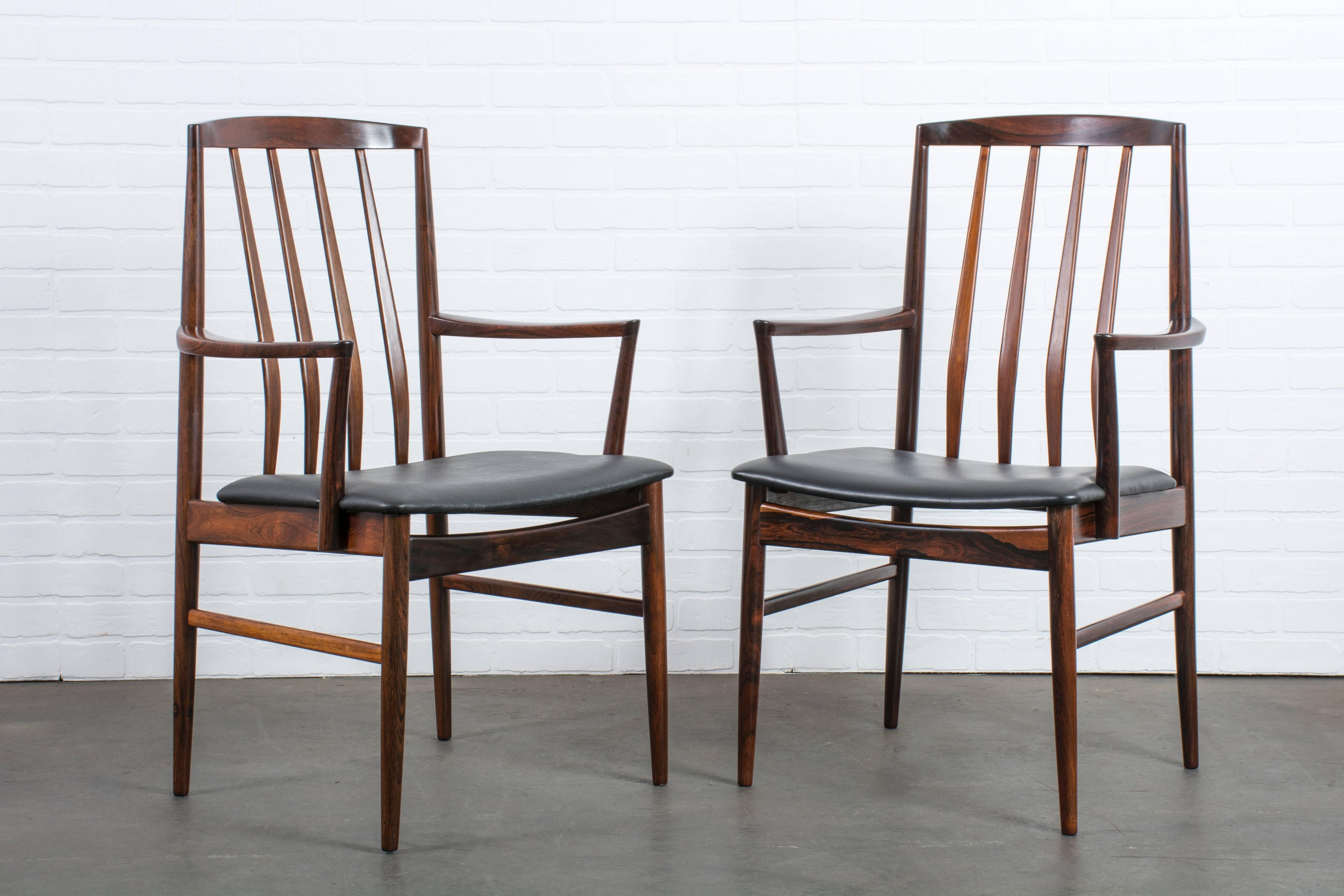 This is a set of six vintage Mid-Century solid rosewood dining chairs that includes two armchairs. Original black Naugahyde upholstery.
The armchairs are 21.5