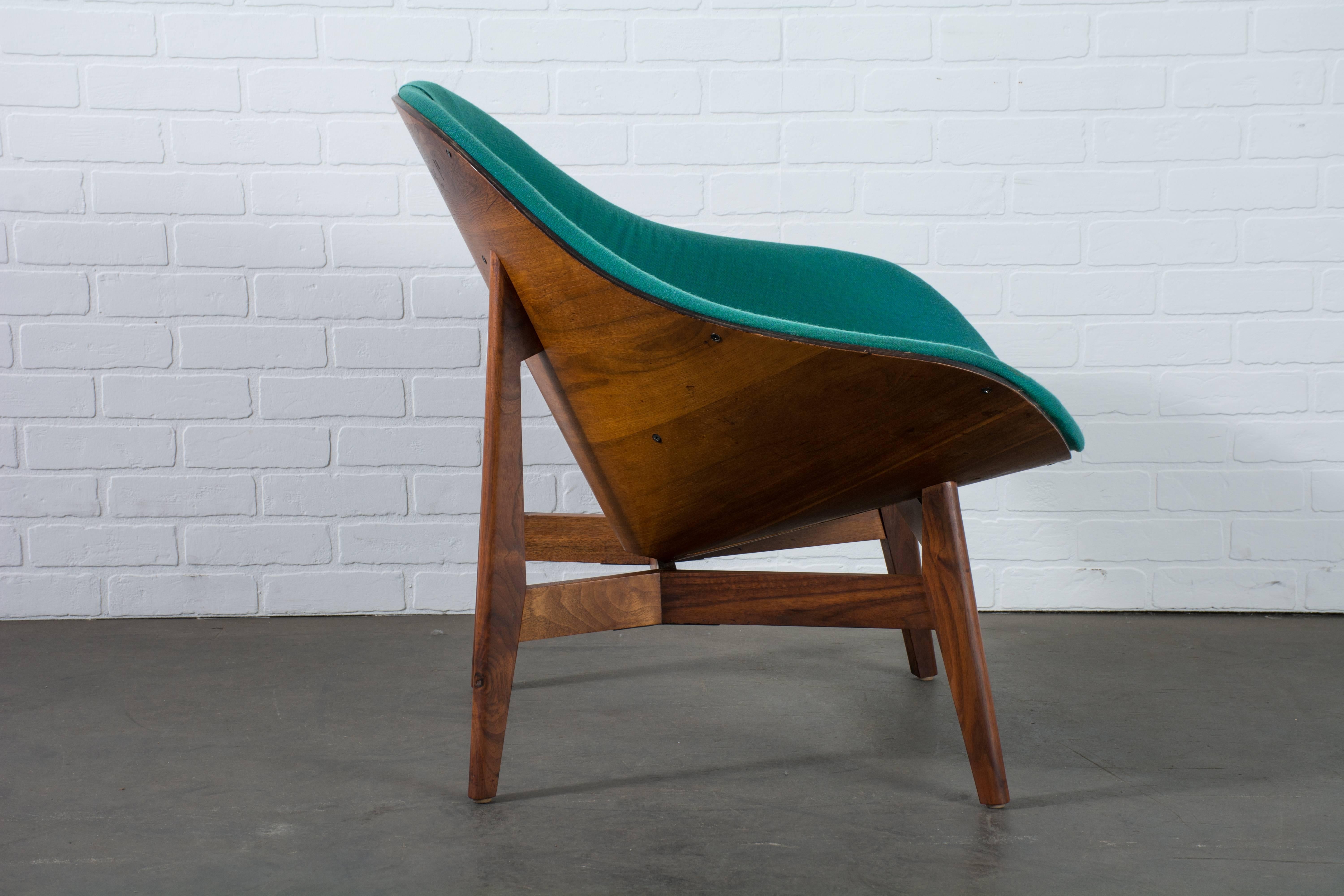 This unique vintage midcentury lounge chair was designed by George Mulhauser for Plycraft.  If features a walnut frame that wraps around the chair and the original tufted teal upholstery.