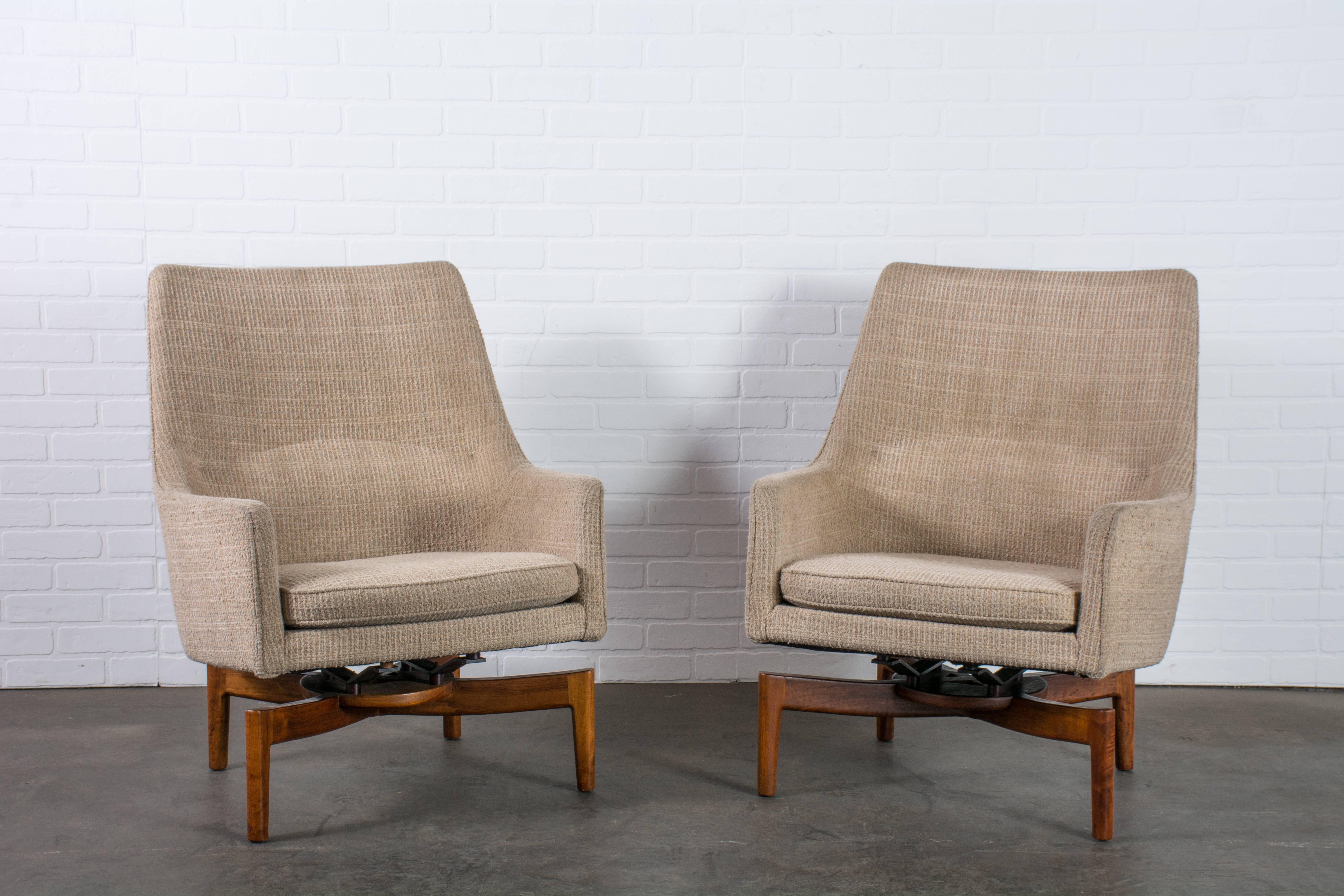 This pair of vintage Mid-Century lounge chairs was designed by Jens Risom, circa 1960s. They feature walnut bases and floating seats in the original beige upholstery.

