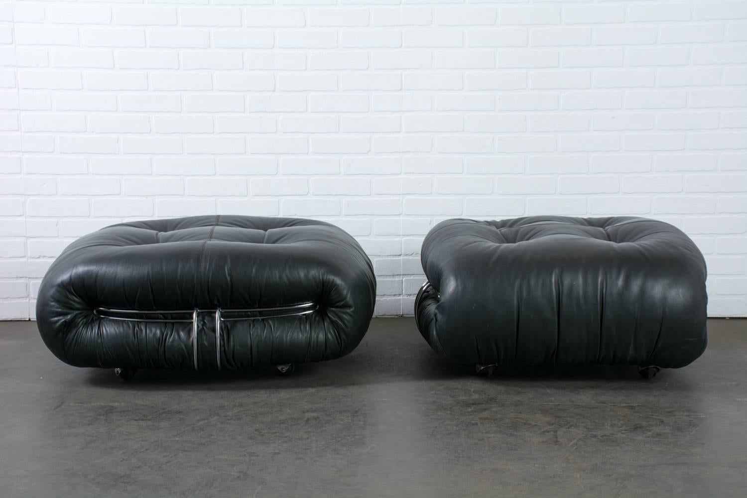 These vintage Mid-Century 'Soriana' ottomans were designed by Afra and Tobia Scarpa for Cassina, Italy in the 1970s. They are black leather with chrome details and rest on four casters. This pair of ottomans match the Soriana sofa and lounge chair.