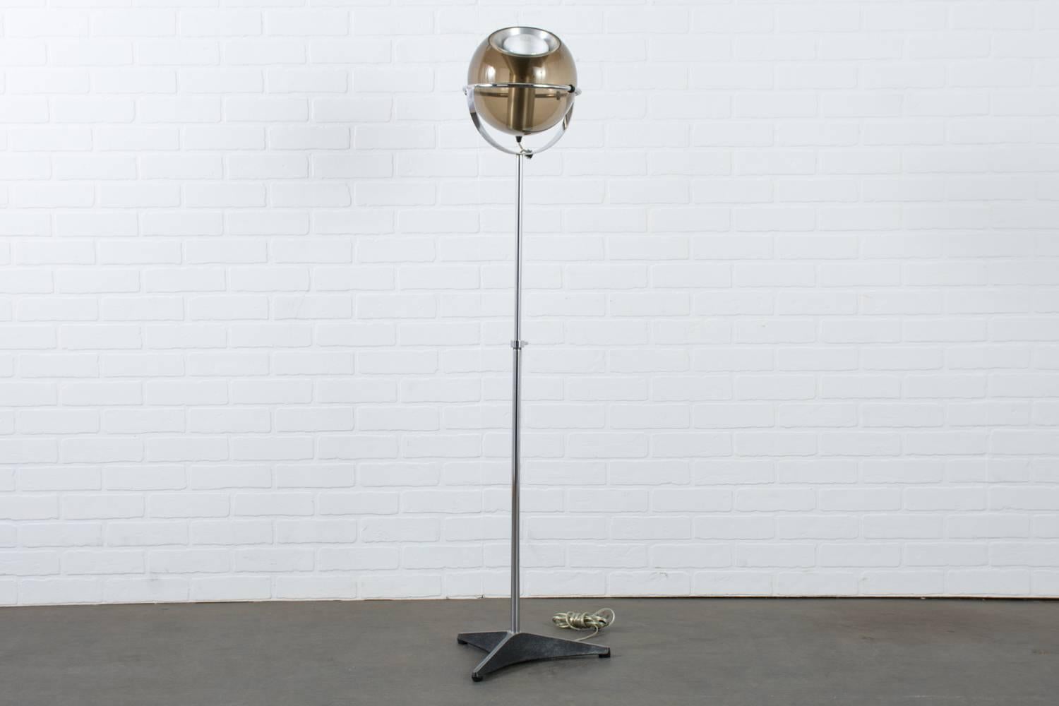 The 'Globe 2000' floor lamp was designed by Frank Ligtelijn for RAAK, Amsterdam in 1961 and has become one of RAAK's most celebrated designs and an icon in Dutch lighting design. It features an adjustable metal Stand with a chrome finish that holds