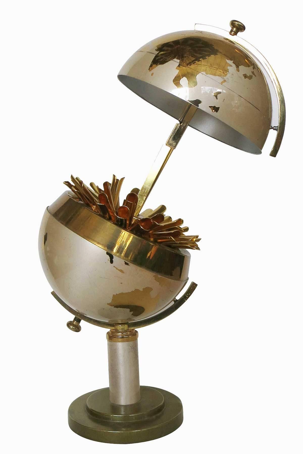 This impressive brushed steel and brass globe cigarette holder by Windmill features a brush steel globe with polished brass continents.

By pulling on the top the globe splits in two opening up to reveal a cigarette holder with 25 small brass arms