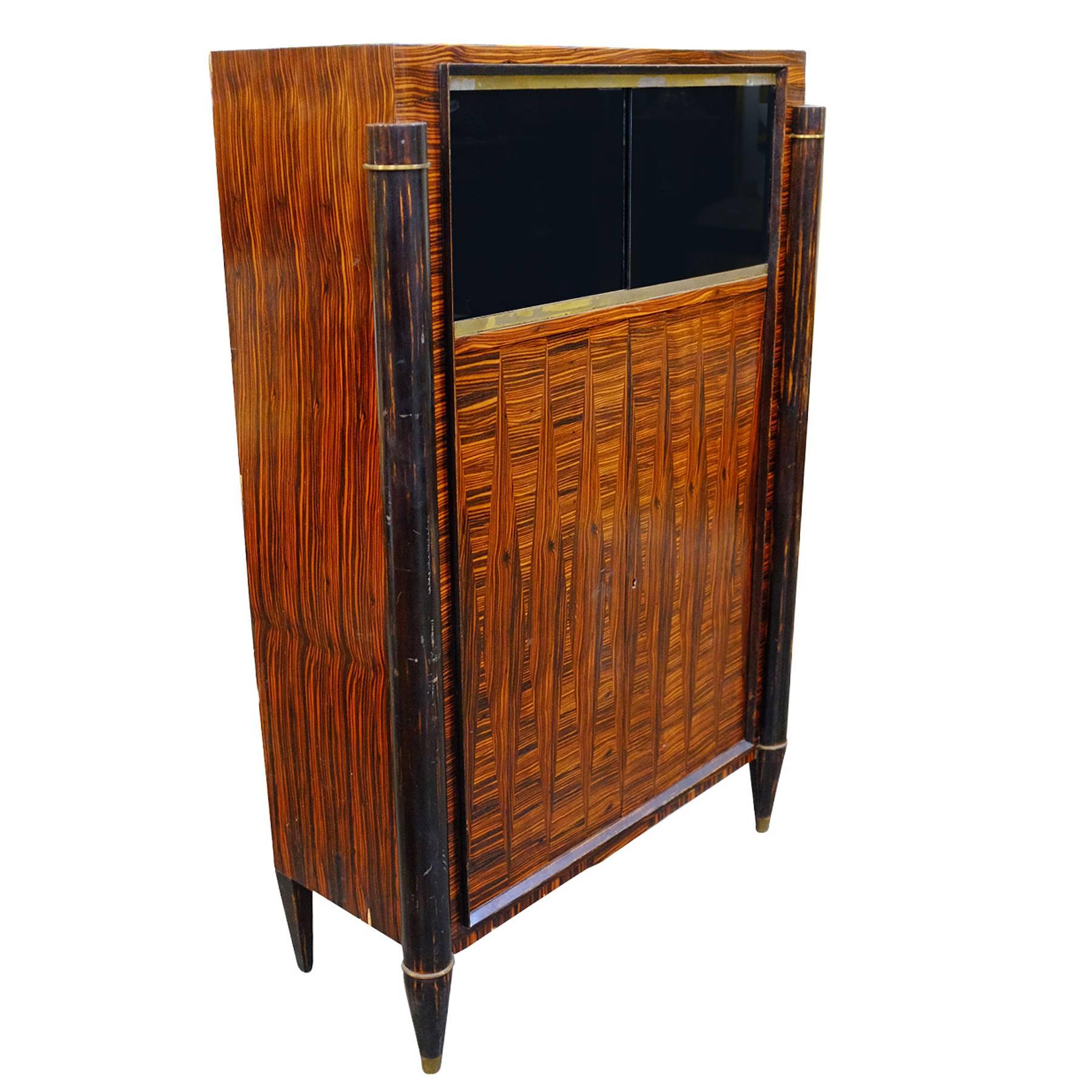 Rare French vitrine cabinet with a dark stained Macassar veneer and two smoked glass sliding doors. On the interior you will find bright maple wood framed by a bronze accent. Underneath are large doors which open up to adjustable shelving for