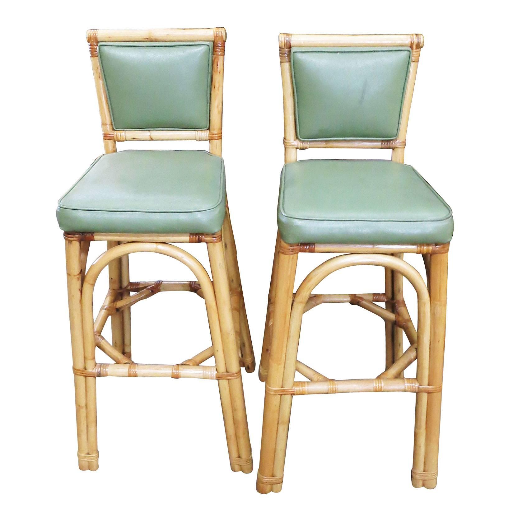 Set of six rattan bar stools with vinyl seats and three strand rattan pull legs, circa 1950. Each stool comes with a fully-formed backrest complimented by arches connecting each leg. 

Custom cushions are included in the price. Simply supply the