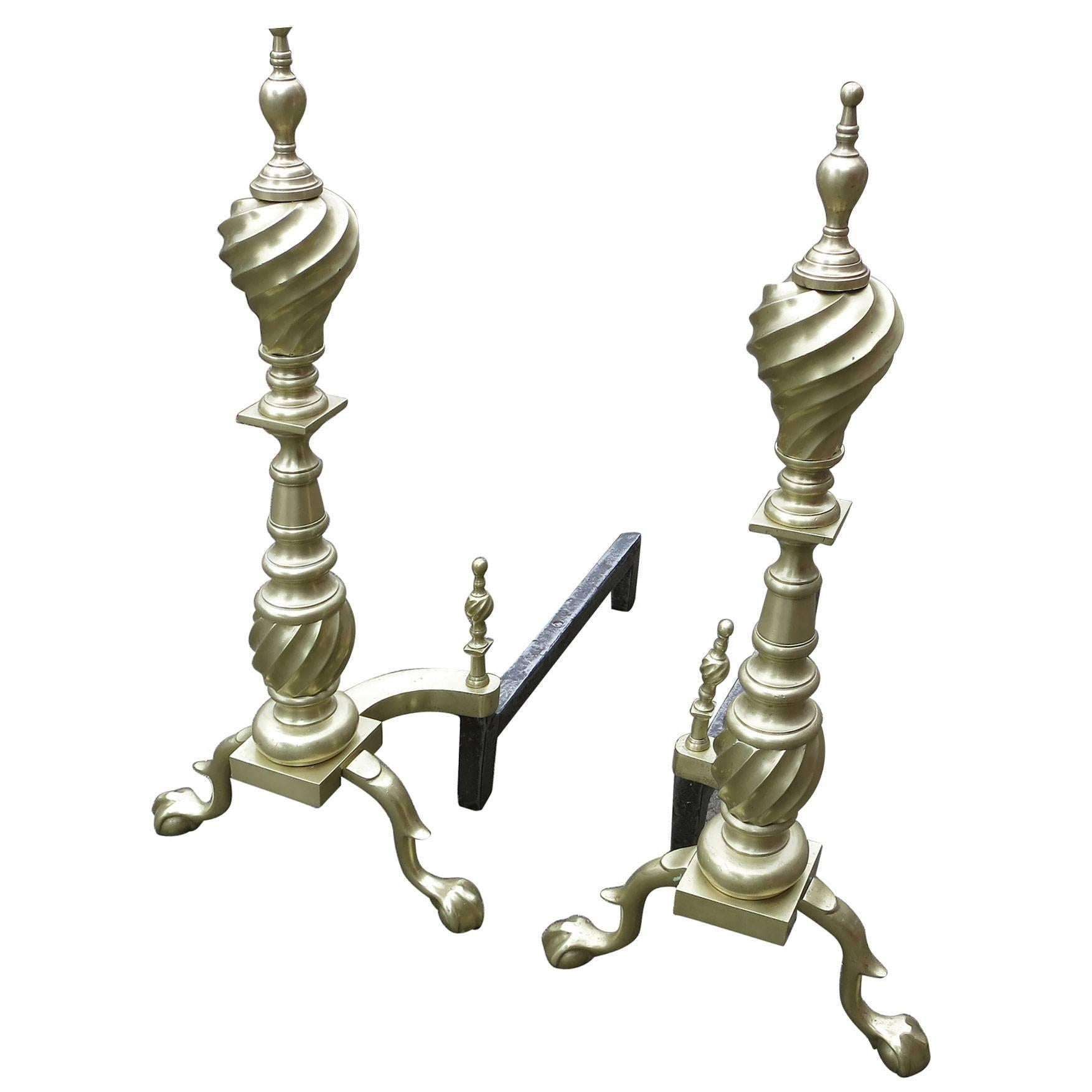 Pair of late Victorian spiral Chippendale style brass andirons with each matching having spiral flame and rounded finials above a spiral baluster-shaped shaft over a plinth (with “cupid's bow” shaped skirt) resting on double spurred cabriole legs