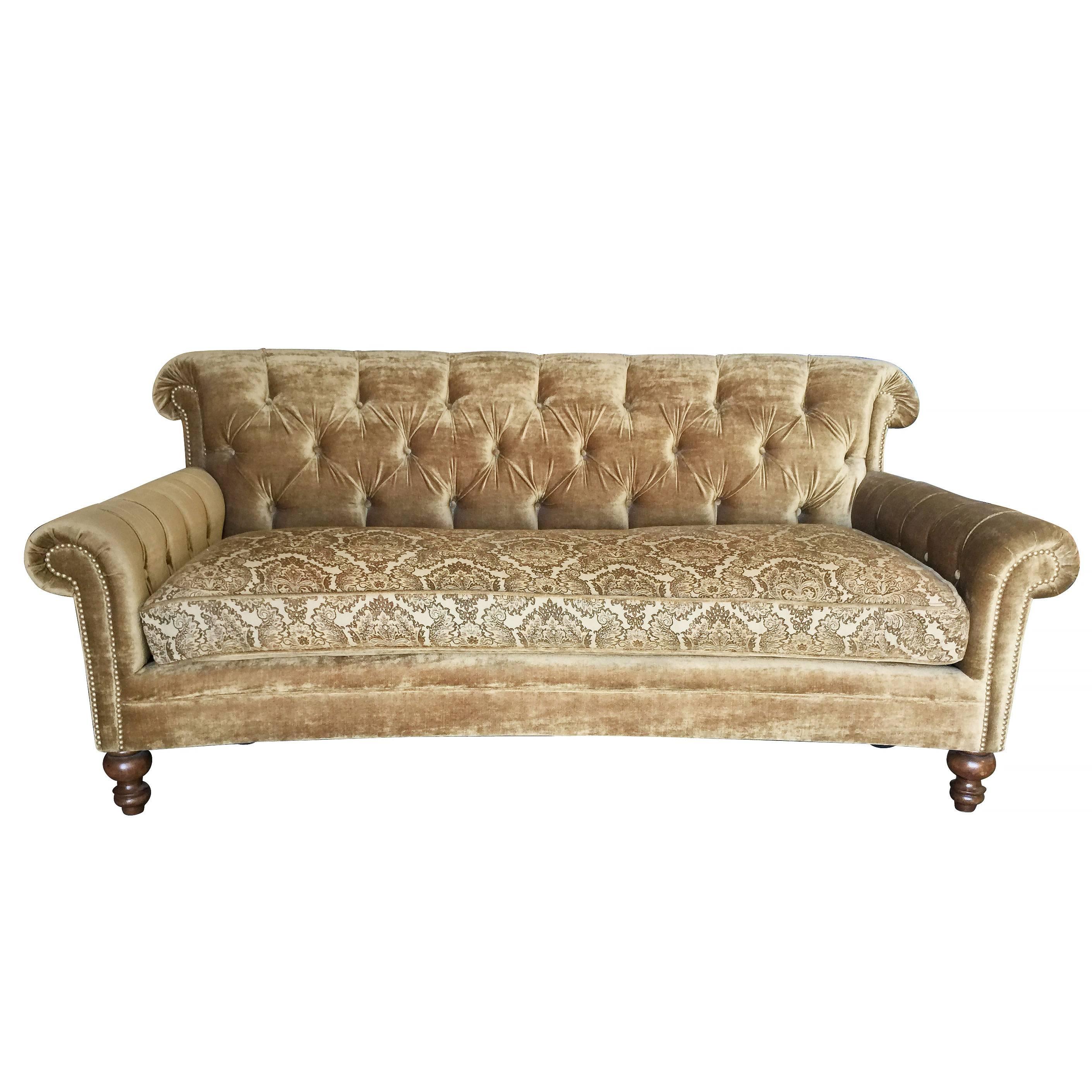 Green Chesterfield style tufted sofa with dark stain legs and scrolling arms.