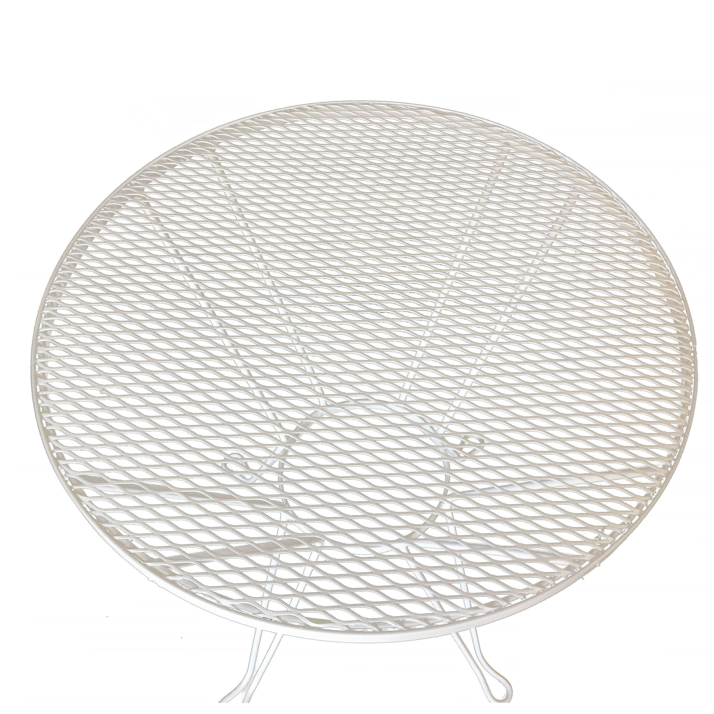 Vintage round outdoor/patio side table with iron scrolling base and steel mesh top by the Woodward company. The table can be repainted in your choice of color,

circa 1950, USA by Woodard.

Measurements: 1.