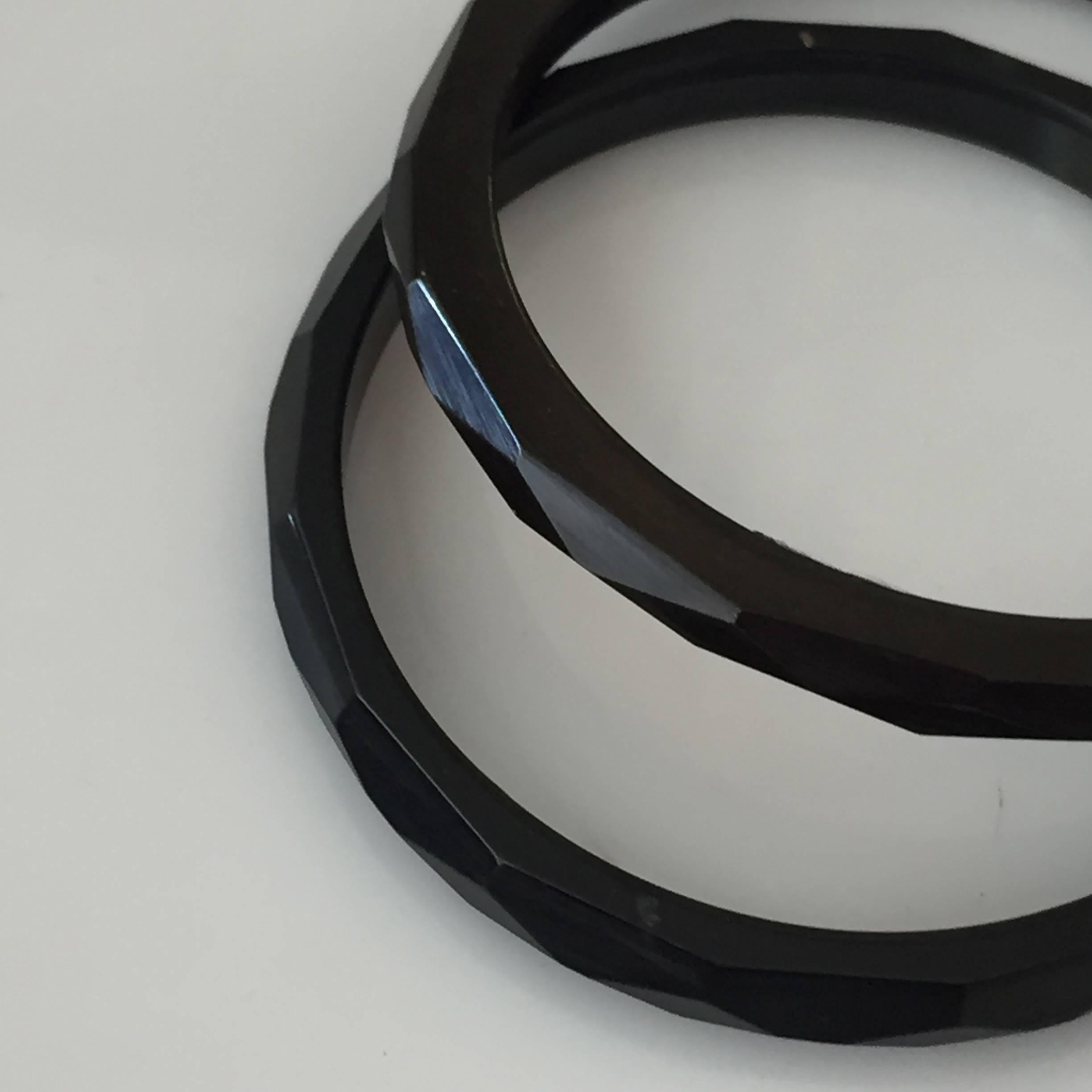 Set of two facetted black bakelite bangles with a highly polished outer rim.

2 3/8