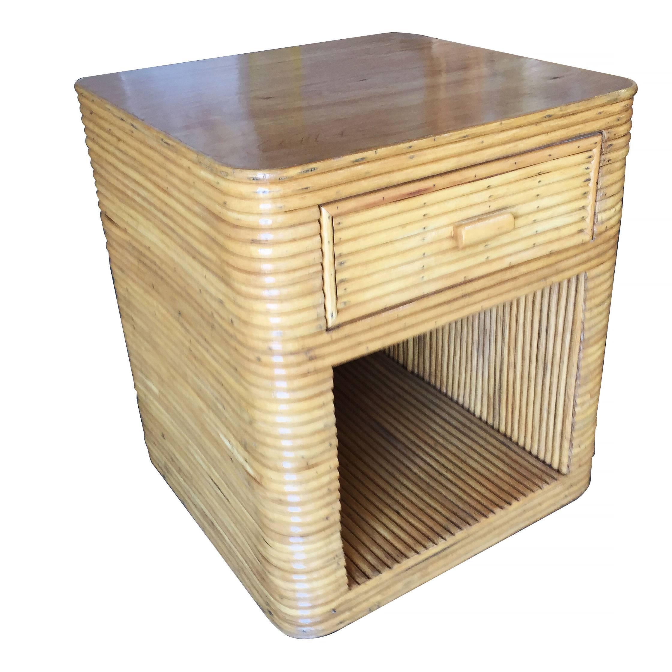 Two-tier stacked rattan bedside table with a mahogany top and pull-out drawer. 

Circa 1970

Restored to new for you.

All rattan, bamboo and wicker furniture has been painstakingly refurbished to the highest standards with the best materials. All