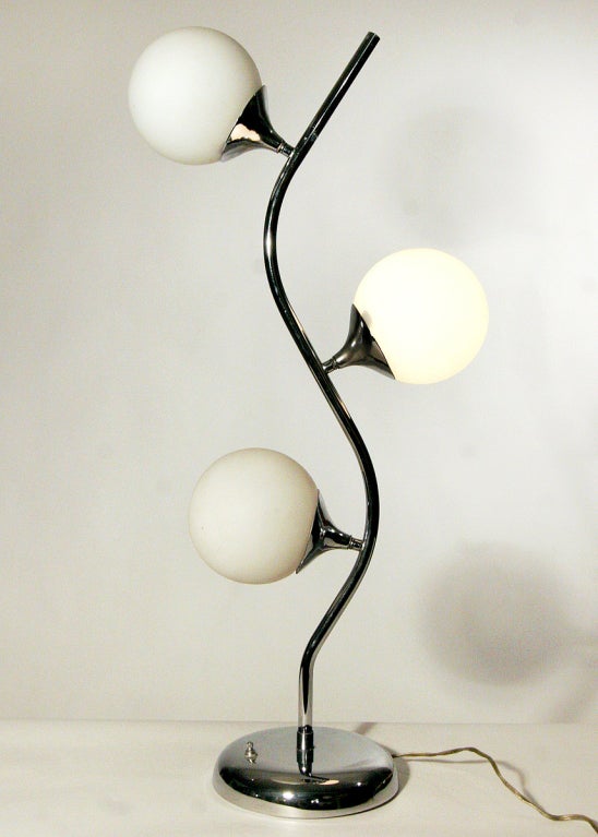 Cette lampe de table en forme de vigne des années 1970, à la manière de Robert Sonneman, comporte trois globes en verre éclairés fixés à une tige et une base chromées. La lampe est en parfait état de fonctionnement et comprend son interrupteur