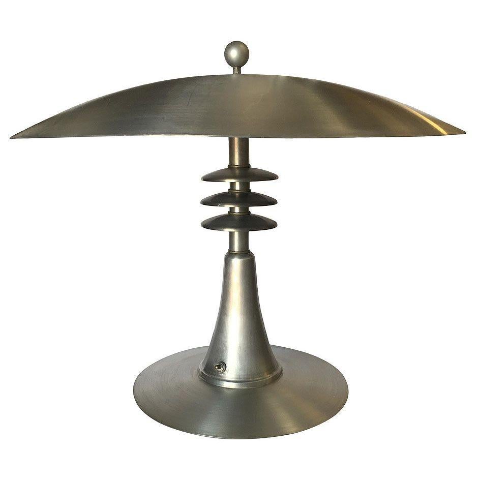 Cette étonnante lampe de table en aluminium de style Art déco comporte un grand abat-jour en aluminium filé de 20 pouces fixé à une base en aluminium filé de forme conique avec des anneaux Saturn fixes au centre.

Voir l'autre listing pour d'autres