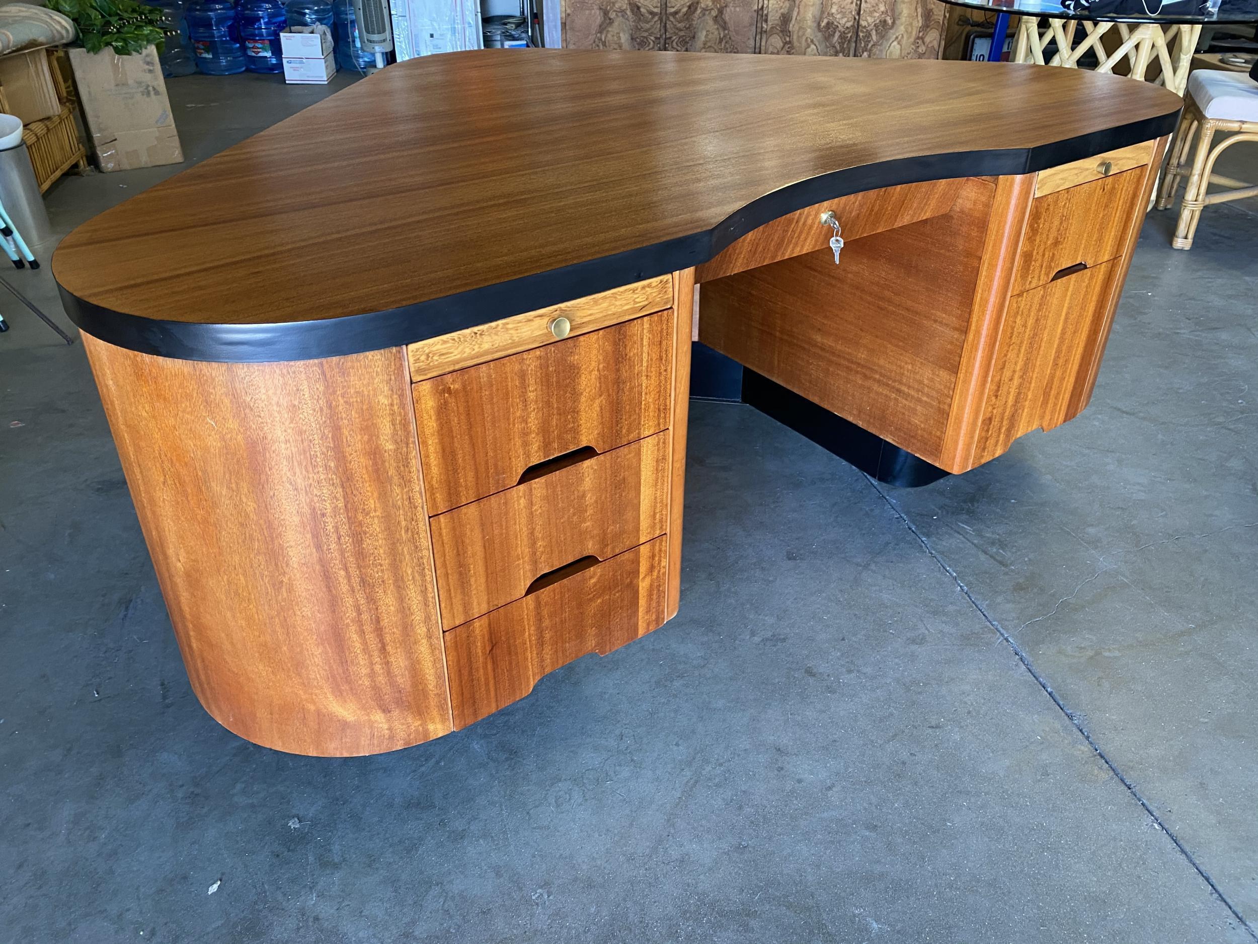 This large American Art Deco desk was designed by Frank Fletcher and manufactured by Fletcher Aviation in Pasadena, California. A design patent number 140,501 was issued to Fletcher in 1945. The triangular desk, which has been refinished in its