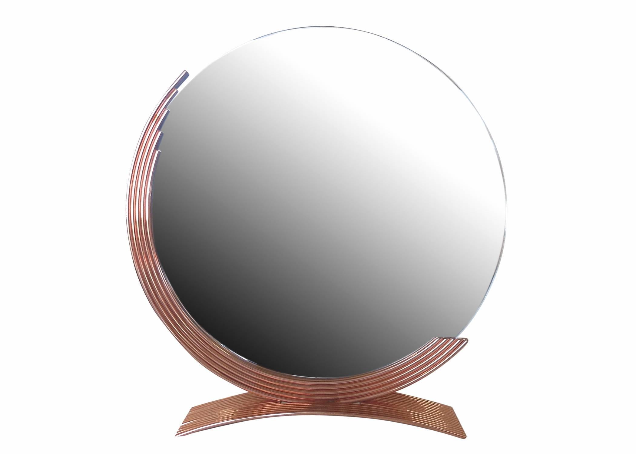 Elegant Art Deco style round table-top mirror features a demilune frame which rests on an arched base both of which are in copper. The beveled mirror was made with care in Los Angeles in the 1970s.

Please inquire us if you would like a different