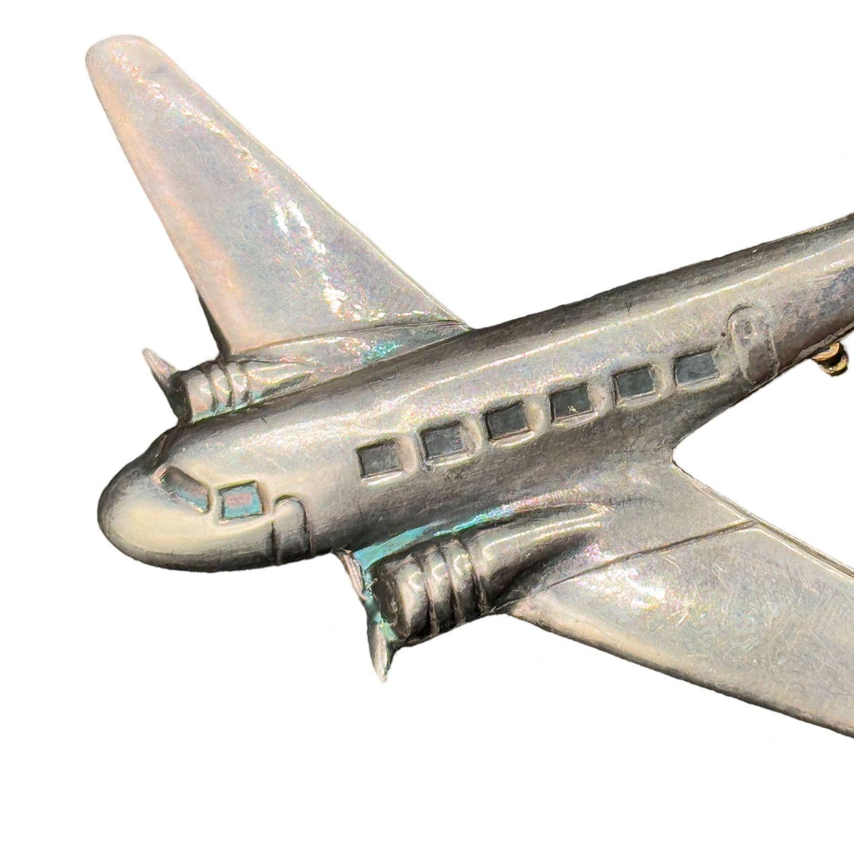 Questa grande spilla d'argento per aereo DC-3 risale agli anni '30 fino alla Seconda Guerra Mondiale, un periodo in cui il DC-3 rivoluzionò i viaggi aerei e svolse un ruolo fondamentale nei trasporti militari. Con una forma che raffigura l'aereo in