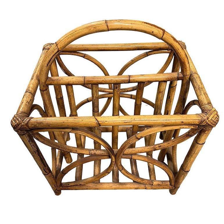 Questo portariviste in rattan splendidamente restaurato unisce lo stile e il fascino vintage al comfort moderno. Il portariviste presenta un design ispirato alle farfalle lungo ogni lato, realizzato in rattan a pali piccoli e dotato di due slot per