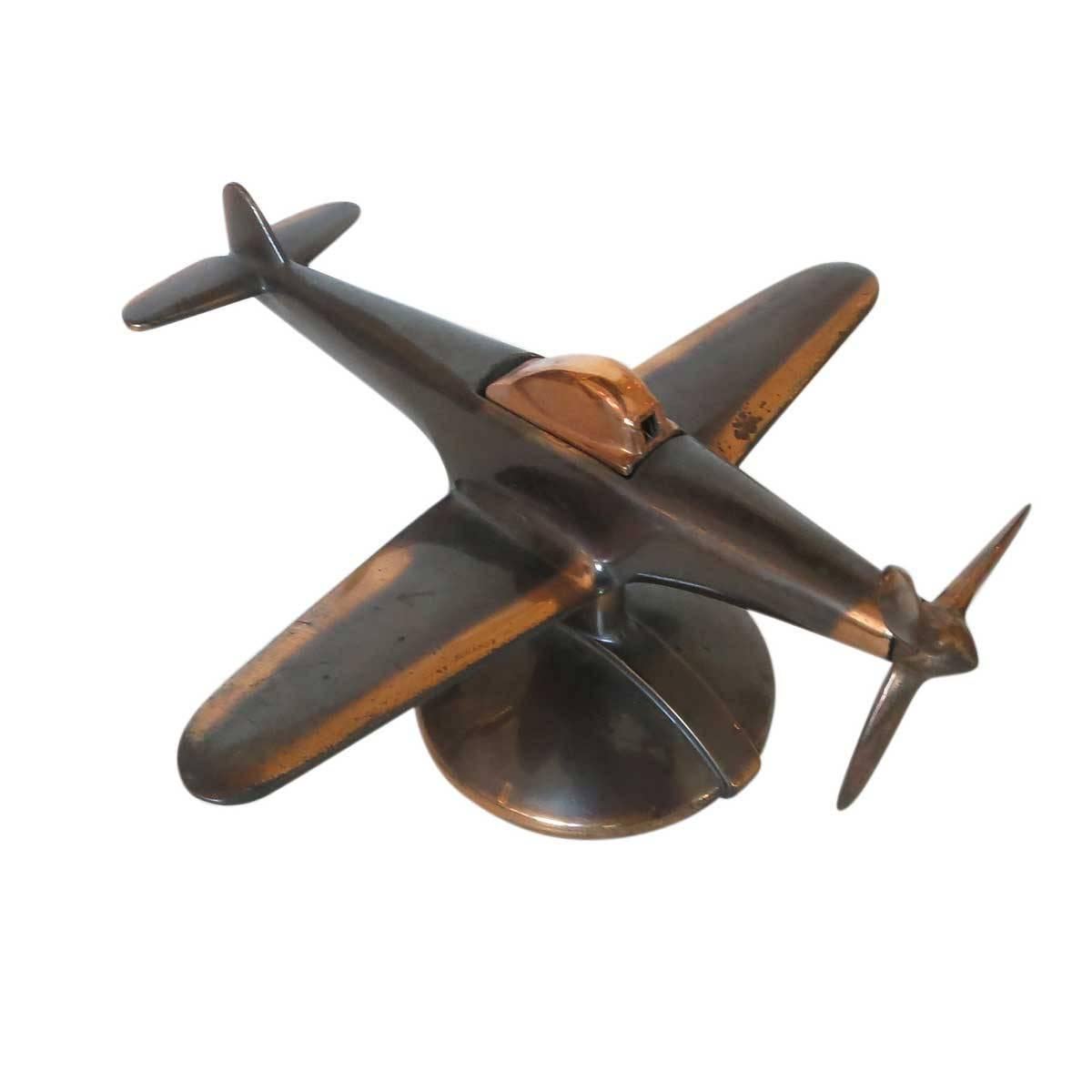 Mid-Century era Negbaur made desktop airplane lighter modeled after the North American P-51 Mustang II fighter plane used heavily in WWII. This lighter features the rare copper metal body and modernist design.

Upon turning the propeller the