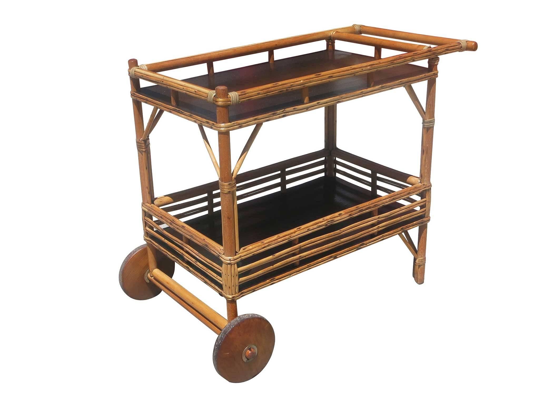 This unique 1940s bar cart features a minimal circular frame with two shelves in mahogany and a removable serving tray on top.

Refinished to new for you.

All rattan, bamboo and wicker furniture has been painstakingly refurbished to the highest